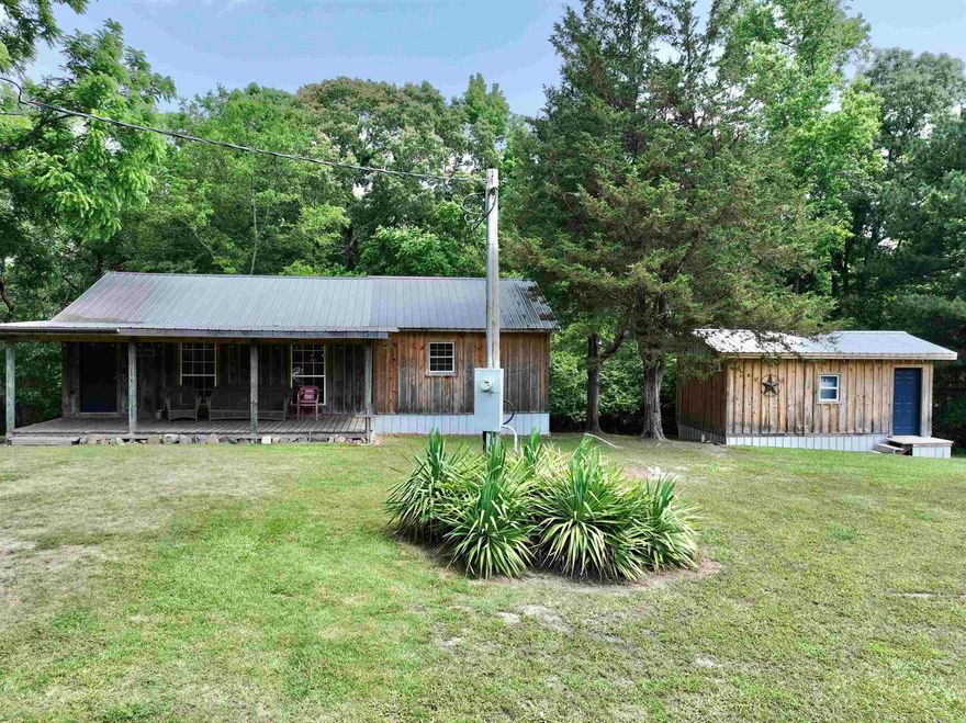 Fantastic opportunity in Rosboro! This charming property spans 3.88 ± acres and includes two cozy cabins (sleeps 12), RV hookups, a picturesque creek, a convenient storage building, and a deck complete with a fun slide for added enjoyment. Nestled in a serene rural setting, it offers the tranquility of country living while being conveniently close to town and the beautiful Caddo River. The main cabin is designed for comfort and relaxation, featuring a generous living area that invites you to unwind. The bedroom provides direct access to a deck, perfect for morning coffee or evening stargazing and a loft for additional lodging. A welcoming front porch adds to the cabin's appeal, offering a peaceful spot for sitting and soaking in the natural surroundings. The additional cabin enhances the property's versatility, offering a comfortable bedroom and a spacious bathroom, making it an ideal guest retreat or rental opportunity. Both cabins blend rustic charm with modern amenities, creating a warm and inviting atmosphere. This property is a perfect blend of convenience, comfort, and rural charm, making it an exceptional find for those seeking a peaceful retreat close to nature.