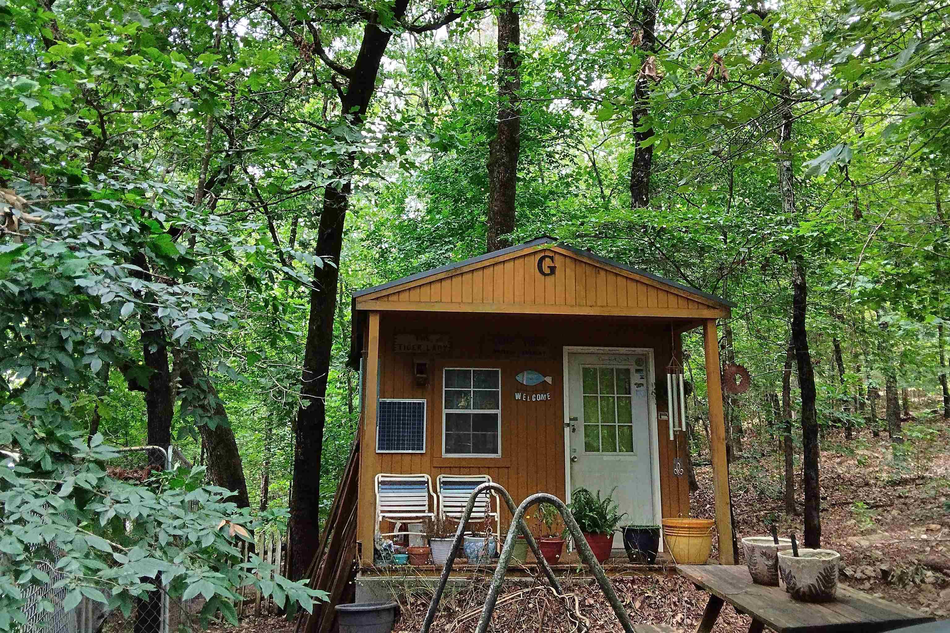 Escape to your own private retreat on 5.5 wooded acres in the peaceful, rural area of Hardy, Arkansas, nestled in the foothills of the Ozarks. This property offers the ideal weekend getaway, situated conveniently near the Spring River, several lakes, historic downtown Hardy, and Mammoth Spring State Park. The land is fully wooded with gravel county road frontage and includes a small cabin, a camper, and a couple of storage sheds. It’s equipped for off-grid living with existing solar power and rural water, though traditional electricity is also available at the road. This unique offering is currently being used as a writer's retreat but would be perfect for preppers or those seeking an off-grid lifestyle, with back-to-nature simple amenities; or with some clearing, could easily be transformed into a charming hobby farm.