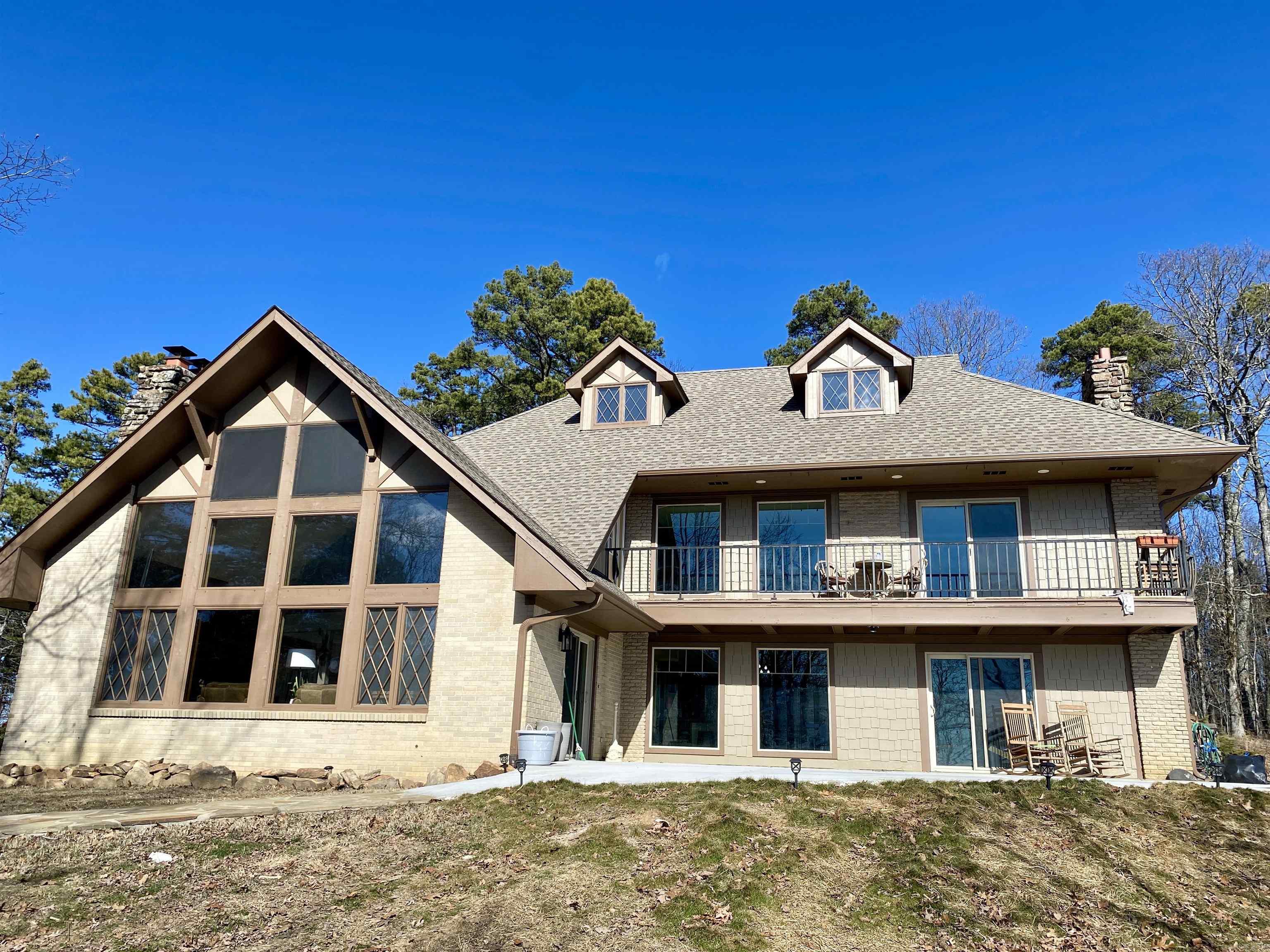 Breathtaking panoramic views await in this stately 5,300 sq. ft. brick home, perched on 4.99 acres bordering the Ozark National Forest. Enjoy sweeping vistas of Mt. Magazine, 40 miles to the SW, and the city of Russellville, 30 miles to the SE, along with stunning valley sunsets. This impressive residence boasts 5 bedrooms, 3.5 baths, and three stories of living space, including a fully finished 1,175 sq. ft. basement. Cozy up by one of the two stacked-stone fireplaces or the additional wood-burning stove while enjoying the spacious bedrooms and abundant natural light throughout. Recent updates include a new roof, fresh carpet, and upgraded LVT flooring in the living and laundry areas. Additional features include energy-efficient windows, stainless steel appliances, and a built-in smoker. Outside, the property is adorned with lush landscaping, spacious patio, abundant wildlife, and a two-car garage. A greenhouse with an attached well-pump house completes the offering. Experience tranquility and sophistication in this one-of-a-kind property surrounded by nature's beauty!