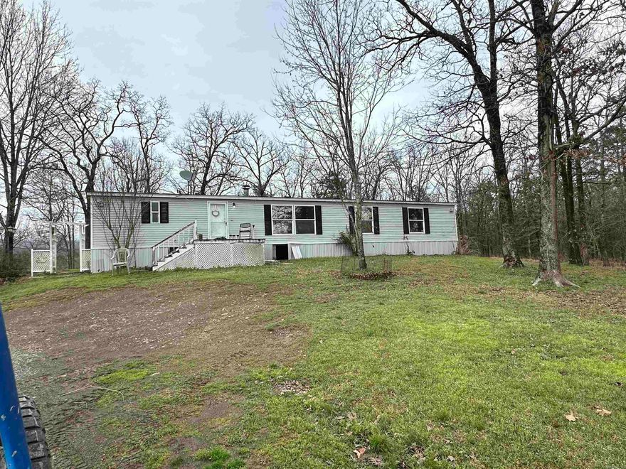 This 1980 mobile home is located on 10 acres and backs to National Forrest.  Garage has dog grooming area and there is a long kennel behind the home.  Beautiful mountain views across the valley. Some of the best views in the area.  Close to Lake Wilhelmina and highway frontage. New survey at time of sale.