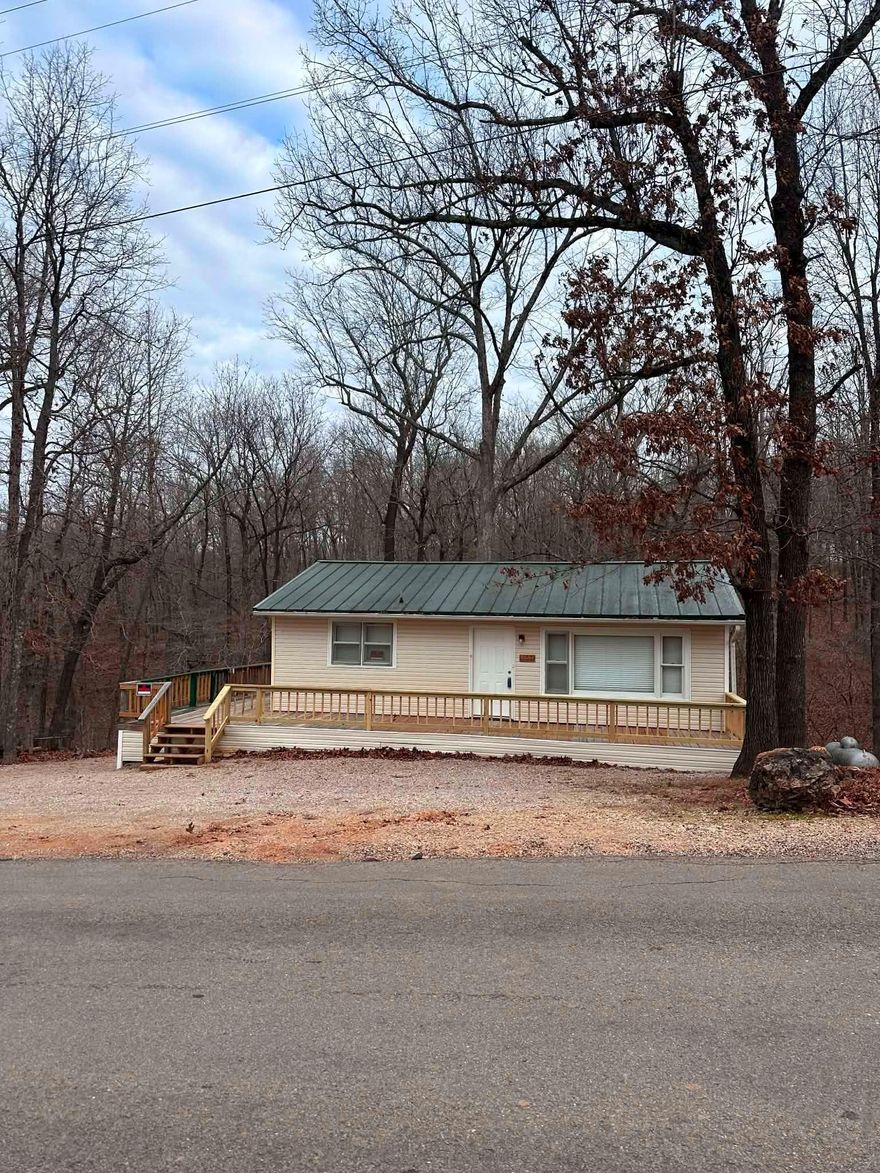 This charming 2 bedroom/1 bath ranch-style home on two lots is waiting for you! Step outside and enjoy your morning coffee on the expansive back deck, nestled among the trees and overlooking a peaceful wet weather creek. The inviting wraparound deck offers plenty of space for outdoor living and relaxation. Inside, the home has been thoughtfully renovated to preserve its classic charm, and the kitchen offers a new oven. Seller has made several updates since first listed! Central AC/heat with new thermostat, plus a new gas heater to boot. The spacious heated walk-out basement is perfect for extra storage, housing everything from recreational gear like kayaks and side-by-sides to your favorite tools on the built-in workbench. The garage door provides easy access, and some cars may fit under the deck and/or inside the basement. Experience comfort and tranquility in this turn-key home, ready for you to move in and make it your own! (wide-angle photography) For more information about Ozark Acres, visit https://ozarkacres.org/