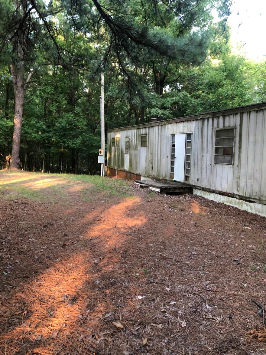 If your wanting OUTSIDE OF TOWN look at this lot for a potential purchase.  While the mobile home does have potential for the right buyer you may want to put a new home on this lot. Lot is being sold AS-IS