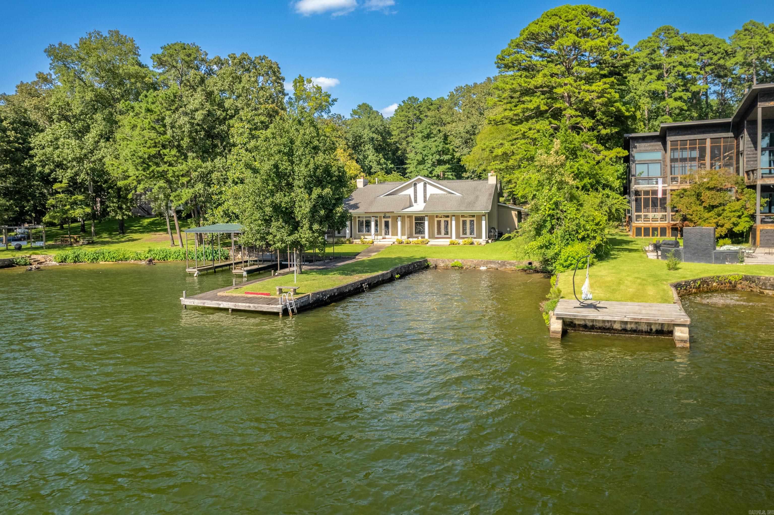 Endless Possibilities on Lake Hamilton – 97’ of Waterfront, Panoramic Views, Prime Location. Unlock the full potential of lakefront livingwith this rare opportunity on the highly sought-after Lake Hamilton. Boasting 97 feet of pristine shoreline and panoramic open waterviews, this expansive 3,299 sq ft home is ready for your personal touch. Whether you're looking to renovate, rebuild, or invest, the truevalue lies in the land and unbeatable location. Set on a level lot with deep water access, the property features a two-stall covered boatdock, offering direct access to endless water recreation. The home itself presents a generous footprint with tons of potential to customize, expand, or start fresh. The layout provides a versatile foundation, ideal for transforming into a luxury retreat. Located just minutes fromHot Springs’ restaurants, shopping, and attractions, this property offers the perfect balance of convenience and privacy. Lake Hamilton isone of Arkansas’ premier recreational lakes, making this a strategic investment opportunity with incredible upside—whether for full-timeliving, vacation use, or development potential. Don’t miss your chance to create your dream lake home