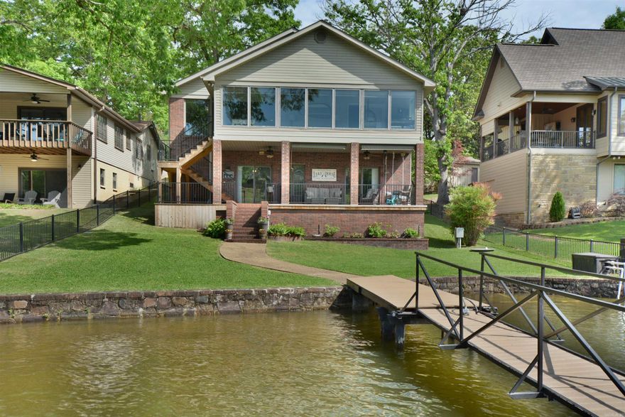 LAKE HAMILTON LIVING MADE EASY!  THIS BEAUTIFULLY UPDATED HOME, 4 BEDROOM 3-1/2 BATH, FEATURES FRESH INTERIORS AND DEEP-WATER COVERED BOAT DOCK WITH TWO LIFTS AND SWIM PLATFORM.  ENJOY A FENCED BACKYARD, SEAWALL, AND COVERED PATIO PERFECT FOR RELAXING.  THE MAIN LEVEL OFFERS A LIVING ROOM WITH FIREPLACE, KTCHEN WITH DOUBLE OVENS, GRANITE COUNTERS, PRIMARY SUITE, LAUNDRY, POWDER ROOM, AND A SUNROOM WITH STUNNING LAKE VIEWS. THE LOWER LEVEL INCLUDES THREE BEDROOMS, TWO BATHS, A SECOUND LIVING AREA WITH FIREPLACE OR MEDIA ROOM, AND STORAGE AREA FOR LAKE TOYS.  LOOKING FOR RELAXED LAKE HAMILTON LIVING--THIS IS IT!