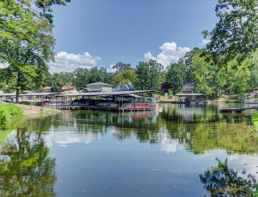 Waterfront Corner Unit on Lake Hamilton  Updated 2 bed, 2 bath lakefront condo in a quiet corner of Lake Hamilton. Located on a dead-end street close to shopping, dining, and medical services in central Hot Springs.  Open floor plan with balcony access from both the living room and primary bedroom. Kitchen includes newer appliances, tile backsplash, LG HI-MACs countertops, and pass-through to the dining area. Bedrooms are on opposite sides of the unit for added privacy.  Recent updates: new HVAC (2023), new appliances, newer windows. Complex improvements include new roof, gutters, dock electrical, and landscaping (2023).