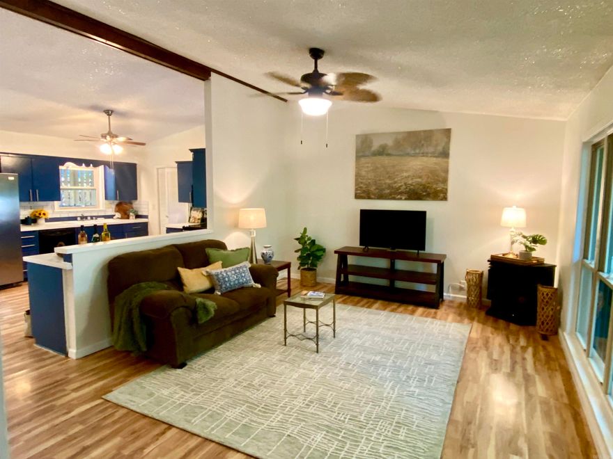 OPEN HOUSE SUN 12-2pm! BEAUTIFUL Mid-Century Modern home with soaring ceilings, an OPEN FLOOR PLAN and fresh new paint throughout! Ready for you to move in and enjoy.... the huge kitchen and living room lead to sliding glass doors into the lush backyard, complete with a patio to host your friends, plus all new Cedar Fencing with convenient gates on both sides. Inside, you'll appreciate the updated bathroom with a lovely glass-doored shower, a spacious primary bedroom with an en-suite, beautiful and durable vinyl flooring, a corner movable gas fireplace for cozy winter nights in the living room, and energy efficient newer vinyl windows throughout.  There's a laundry room off the kitchen, and a one-car garage with a large walk-in storage closet.  Let's talk about LOW MAINTENENCE....NEW ROOF, NEW FENCE, NEW HVAC, NEW HOT WATER TANK, NEW PAINT, newer model VINYL WINDOWS that flip in for easy cleaning, plus a NEW SHOWER. Seller did all this work, then needed to move back north to be near family. GRAB THIS AMAZING HOME NOW, before it's gone!