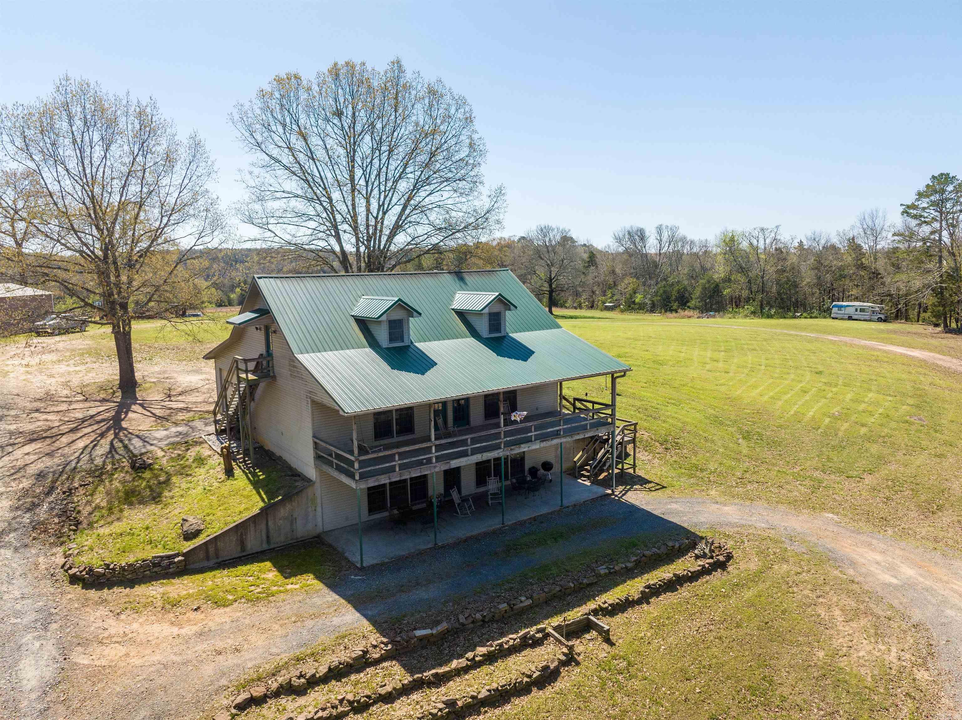 Peaceful country living at its best! This property boasts 10 acres that include a pond and livestock is permitted, so the perfect outdoor space for a garden or farm animals. The one-owner home features three levels. The main level includes a beautiful living area surrounded by solid pine, an open-area concept kitchen with handmade pine cabinetry, and a half bath. The second level features the oversized primary bedroom that offers a sitting area and an easy step-in shower in the bathroom; and the additional two bedrooms are Jack and Jill style. The third level has a finished bonus multi-purpose room and the water heater & HVAC, so easily accessible to add an additional bath. The roof has a lifetime warranty. The 30x50 shop includes electric and water. (Mineral rights DO NOT convey) Just minutes to Cove Creek Rec Area to launch your boat for a day on the lake. Call today for your showing!!