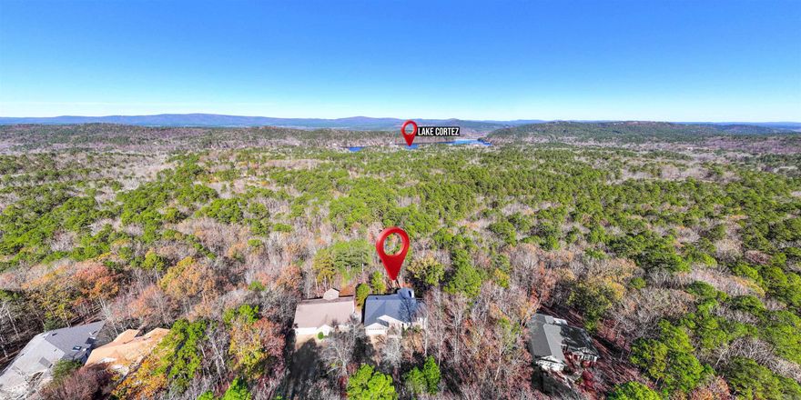 Enjoy the panoramic view from this one level home on over 1/2 Acre, high above Hot Springs Village! Check out the Engineered Hardwood Floors, High Ceilings, Wood-burning Stone Fireplace, Granite Island Kitchen with a Pantry and an Eating Area w/Bay Window! Both the Living Room and Guest Bedroom open to the back Deck with Porch Swing! The Den/3rd Bedroom off the Entry offers great utility however you choose to use it. The Primary Bedroom also boasts the View, and the Ensuite features a Corner Jetted Tub! BRAND NEW ROOF! BRAND NEW WATER HEATER! This is a DOUBLE LOT (over 1/2 acre!) 26,000 gated acres in Hot Springs Village offers 11 Lakes & 9 Golf Courses (with Restaurants), Tennis, Pickleball, Indoor & Outdoor Pools, Fitness Center, Miniature Golf, Bocce Ball, Archery Range, 20+ Miles of Walking Trails, 24 Churches, 200+ Clubs/Activities, and much more!