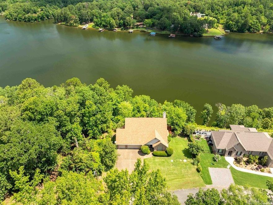 Nestled in an exclusive gated community, this custom-built lake home offers breathtaking panoramic views of both the shimmering water and majestic mountains. Designed for comfort and style, the property boasts three spacious bedrooms and two and a half baths, blending modern updates with timeless elegance.  Step inside to discover gleaming hardwood floors and stunning granite countertops, creating a warm and sophisticated ambiance. The newly installed roof, air conditioning, water heater, and upper deck ensure peace of mind and optimal efficiency. A whole-home water filtration system adds an extra touch of convenience.  Enjoy resort-style amenities within the community, including a sparkling pool, championship golf course, tennis courts, a welcoming clubhouse, and a full-service marina. Whether you're savoring a quiet evening on the deck, working in the meticulously maintained basement workshop, or taking advantage of the world-class amenities, this home is a sanctuary of luxury and relaxation.  Every detail has been carefully maintained, making this property move-in ready for those who appreciate quality craftsmanship & exceptional living. It’s more than a home, it's an experience