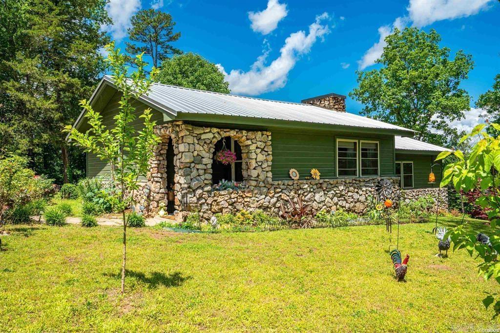 Escape to serenity in this beautifully remodeled 3-bed, 2-bath retreat on approximately 1 acre! Overlooking the tranquil waters of Lake Hamilton, this home has a perfect blend of rustic charm and comfort. Completely renovated in 2022, it features a metal roof, new insulation, flooring, cabinets, and windows. Enjoy the convenience of a staying refrigerator and new Bosch dishwasher. The storm cellar provides added peace of mind, and the concrete patio above it is perfect for taking in the surroundings. Surrounded by tall trees and nestled in a quiet area, this home feels like a cozy cabin getaway. Make it yours and start creating memories!