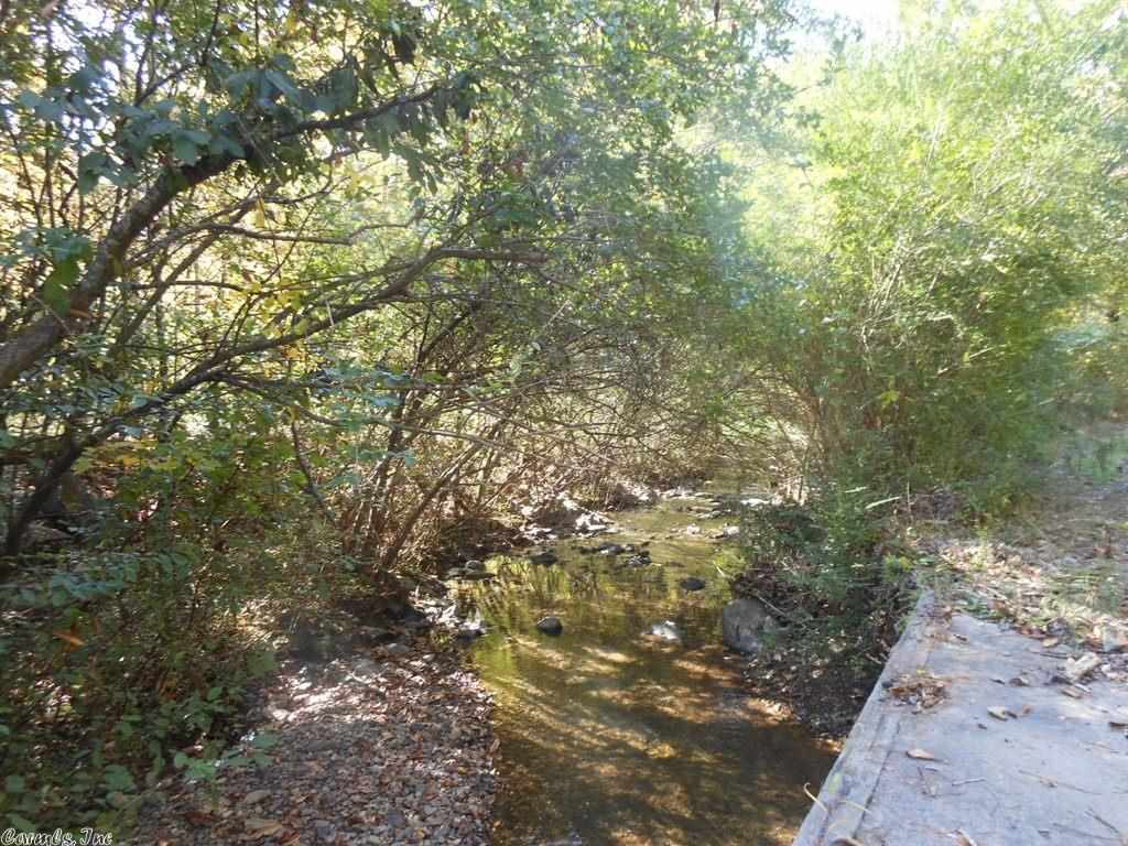 10 Acres with a creek! Beautiful wooded 10 acres with a year round creek with Highway frontage in Wickes. Great place to began your dreams whether or not your dream is to build a home or own your own business, it can be cleared to suit you! Call us today for your showing!