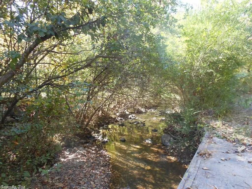 10 Acres with a creek! Beautiful wooded 10 acres with a year round creek with Highway frontage in Wickes.  Great place to began your dreams whether or not your dream is to build a home or own your own business, it can be cleared to suit you! Call us today for your showing!