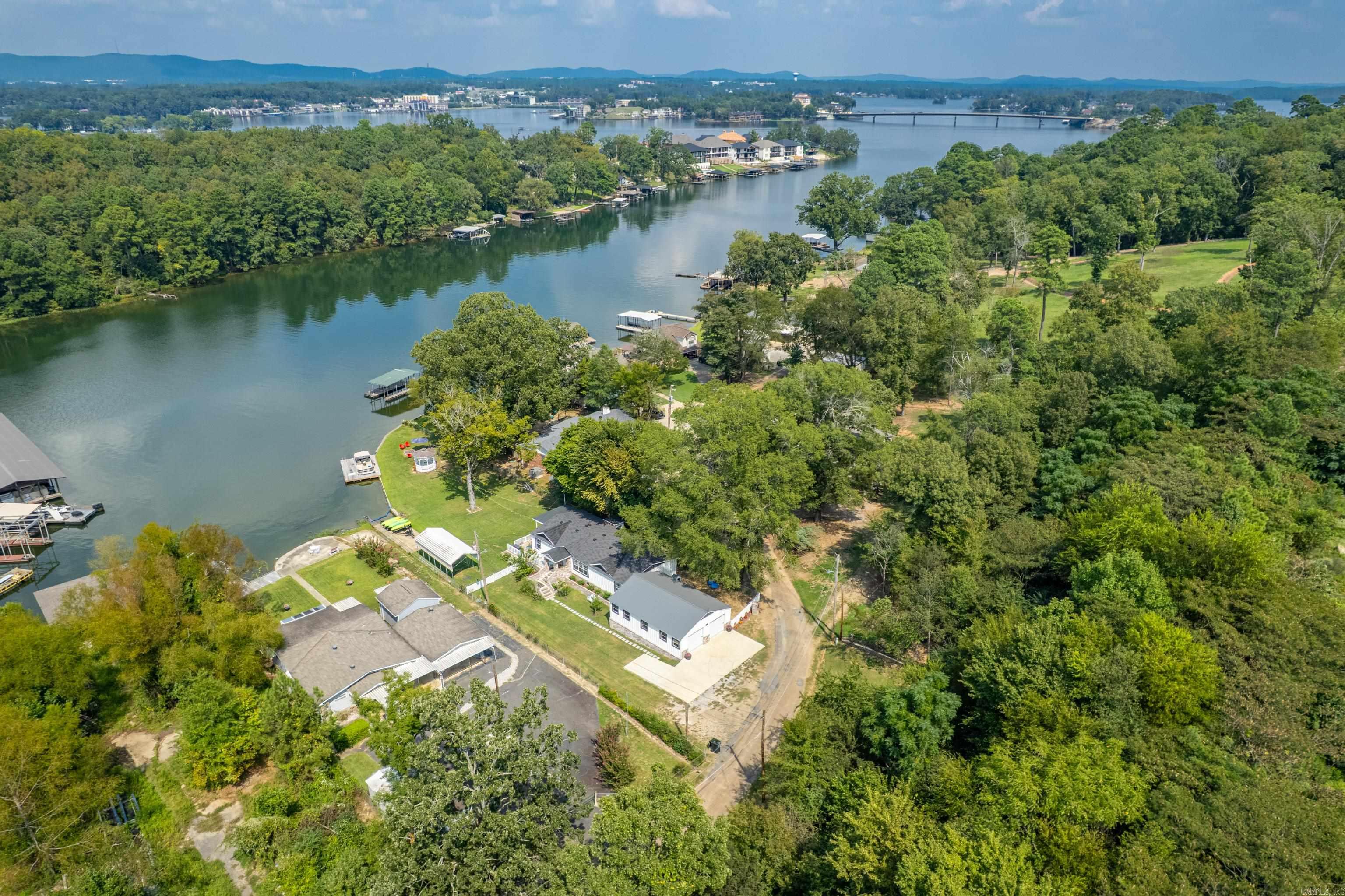 Lakefront living at its best! Discover this beautiful lakefront home featuring a private boat launch, boat slip with a swim deck, and a spacious covered porch overlooking a peaceful cove. With plenty of outdoor space, it's the perfect spot for relaxing or entertaining by the water. Tucked away on a quiet street with only six other homes, you'll enjoy both privacy and serenity. This property also includes an additional lot across the street-- an excellent opportunity for a tiny home, guest house, or additional investment, all with lake views. This home can be purchased fully furnished with an acceptable offer and could serve as a wonderful primary residence, vacation home, or an income producing short term rental-comfortably sleeping 8-12 guests. No permit is required since it's outside city limits, yet you'll still be just minutes from restaurants and grocery store for added convenience. Call today to schedule your showing!