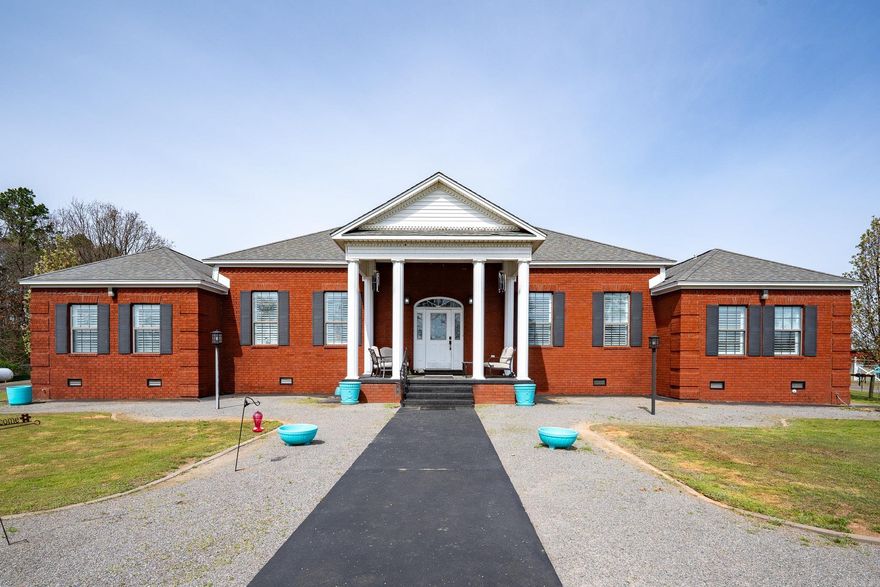 Nestled on 9.5 private, tree-lined acres, this gated entry property offers space, privacy, and versatility. A fully paved circular drive and wrap-around driveway welcome you to this 3,241 sq ft home featuring 4 bedrooms and 3.5 bathrooms with soaring 15-foot ceilings throughout the living areas and bedrooms.  Inside you’ll find a spacious layout including a living room, dining room, two flex rooms, and a primary suite with a large walk-in closet.  Step outside and the property truly shines. A covered breezeway leads to expansive open acreage ideal for outdoor living and recreation.  The land includes multiple outbuildings, five storage units, and a large detached garage perfect for RV storage, workshop space, equipment storage, or hobby use. The fenced acreage provides opportunities for horses, hobby farming, animal breeding, or simply enjoying private country living.  This unique property offers the rare combination of privacy, acreage, and functional space while still being within a 5 minute drive to town.