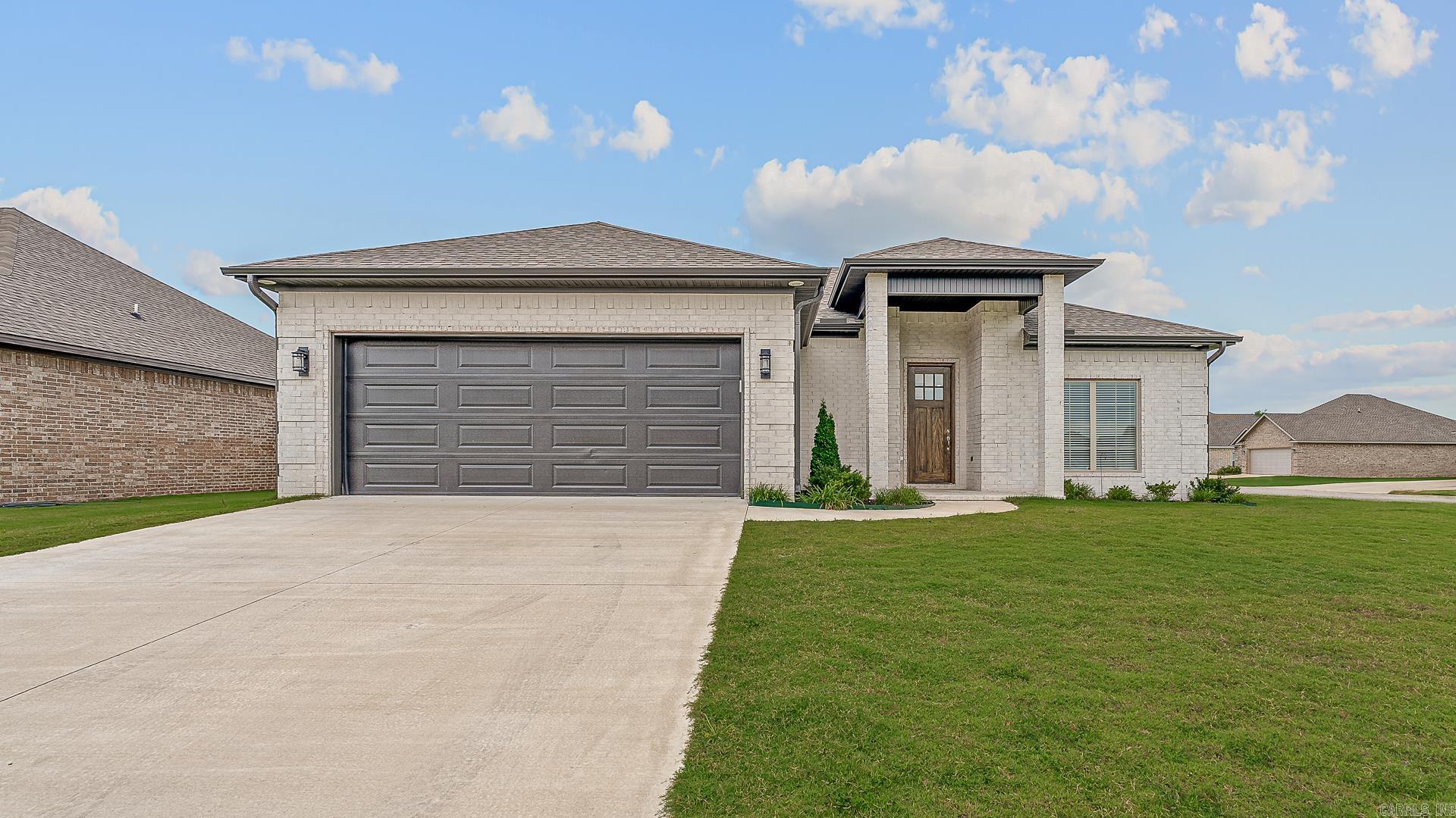Built in 2023, this 3-bedroom, 2-bath home offers 1,441 square feet of thoughtfully designed space with a built-in saferoom, modern electric fireplace, screened-in back porch, and premium upgradesāall on a spacious corner lot. Polished, private, and perfectly positioned, this meticulously-maintained home features crisp white brick, rich laminate flooring, chrome fixtures, and an open-concept layout ideal for everyday living. The kitchen showcases granite counters, stainless appliances, a subway tile backsplash, and a large breakfast bar and kitchen island. The primary suite includes a glass walk-in shower with removable accessibility features, while the screened porch and oversized lot extend your living space outdoors. With new construction efficiency, a two-car garage, and easy access to Jonesboro, this home blends comfort, style, and smart design.
