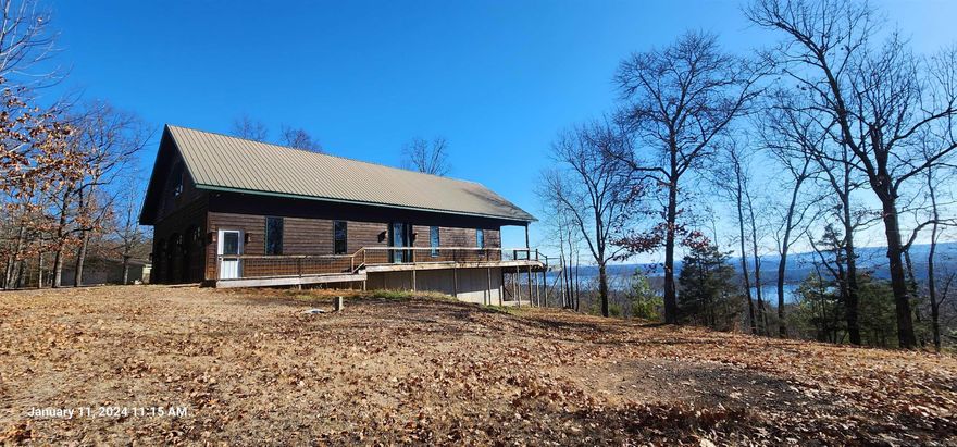 Nestled on 7.62 acres in the hidden treasure Fairfield Bay, this charming home has panoramic views of the beautiful Greers Ferry Lake. The residence features two bedrooms, two livening spaces or use one as a game or theater room, a spacious three-car garage, offering both comfort and convenience. Cabinets are made from gorgeous maple wood cabinets with chestnut inlay, teak wood flooring, all Anderson windows, decorative entry & exist doors, tv built into kitchen cabinets for all your favorite cooking shows, new instant hot water heater, whole house vacuum system hvac less than 1 year old & metal roof to boast! Home still looks new!  All Surrounded by the beauty of nature, residents can enjoy the serenity of the lake while still having easy access to local amenities. Fairfield Bay provides an array of recreational options, including two golf courses, three community swimming pools, and an abundance of outdoor activities such as hiking trails and side-by-side trails spanning nearly a hundred miles. Additionally, residents can indulge in leisure activities like mini-golf and bowling, enhancing the appeal of this weekend getaway or forever home.