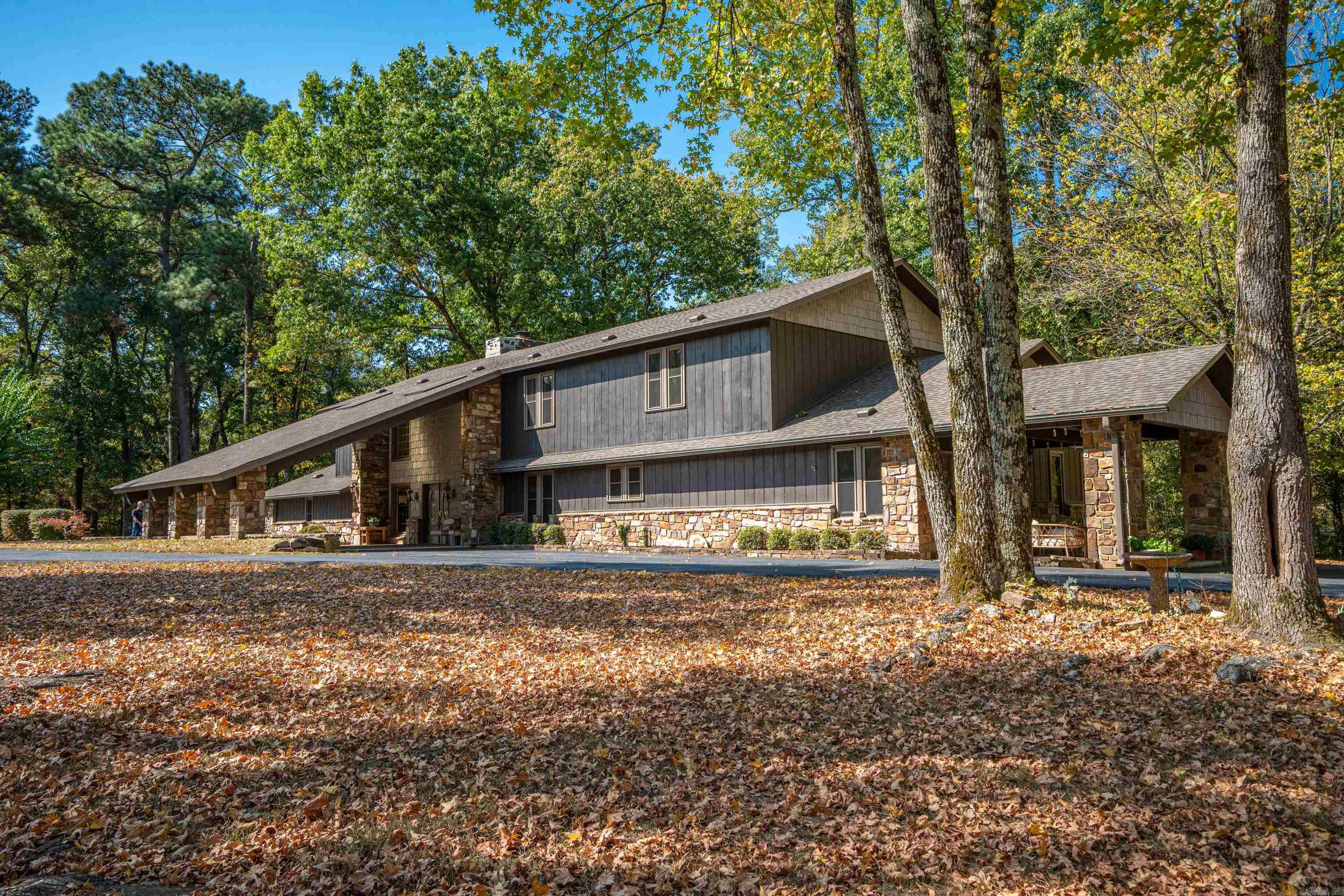 Country Retreat on 5+ acres! Discover your own private oasis in this lovely 7-bedroom, 4.5-bathroom home nestled on 5 acres of park-like grounds. With rustic charm and modern amenities, this home offers the perfect blend of comfort and style. Two master suites, one on each level. Total of two bedrooms down and five up. Two car carport and 3 car detached 30X40 garage with auto door openers. 50 amp RV plug in in garage. One covered patio & one uncovered. New architectural shingle roof in 2022. Three central heat & air units with natural gas heat. Site built stone fireplace currently used with gas logs. 12X20 storage building with lean-to on each side. A very unique custom built home.