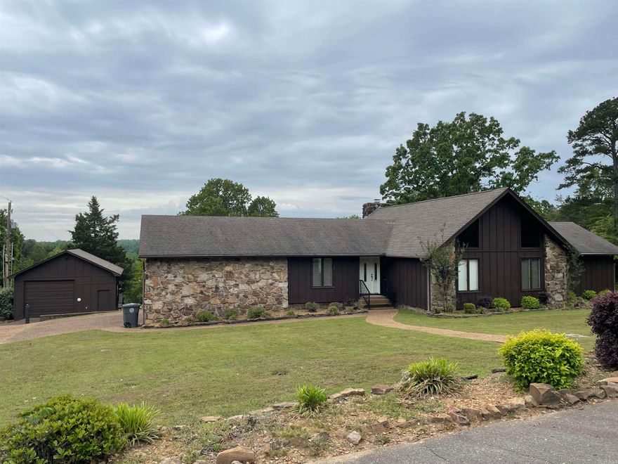 Peaceful country living with easy access to the Bypass. Sunken living area has a beautiful rock fireplace (gas), wooden ceiling beams & built in bookcases. Kitchen has granite countertops plus built in breakfast table. Large, separate dining room. Lots of updates including new decks (2024); new exterior paint on shop & home (2024); new carpet (2023); AC unit & water heater replaced (2022); new microwave (2024).  Primary suite has walk in closet, walk in shower, linen closet & access to rear deck.  Walk in shower & two sinks in the second bathroom. Shop is apprx 624 sq ft & features both a walk through door & a roll up door which is apprx 9'10" tall. Nicely landscaped in front & back yard. Storage area underneath the home includes shelving.