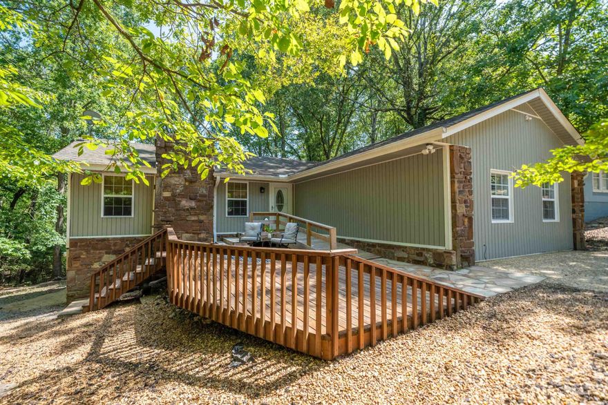 Easy living in this warm and inviting 3 bedroom, 3 full bathroom home in Hot Springs Village. No carpet in any rooms. Easy "no steps" entrance to the home, all light switches are lowered,  MASSIVE walk-in shower and expansive walk-in closet in the primary suite makes this home wheelchair friendly. Large storage area under the house has a slab floor that allows it to double as a workshop. Choose to enjoy the front deck overlooking the water feature or the back deck for wooded outdoor dining. There is an additional flex space to use as a home office, craft/hobby area, or whatever your heart desires!