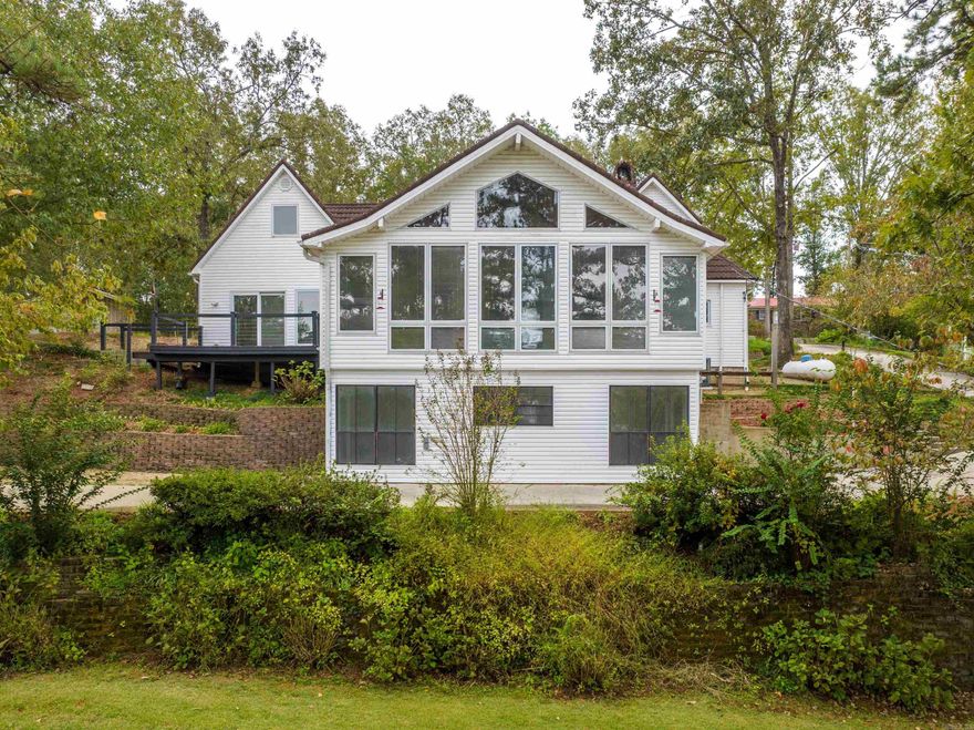 Nestled on Lake Hamilton, this charming two-story, 4-bedroom, 3-bathroom home is the ideal family getaway or a lucrative short-term vacation rental, this property offers a serene escape like no other. This home is designed for comfortable living with four generously-sized bedrooms and three bathrooms, ensuring there's room for everyone. Enjoy the changing seasons in the inviting sunroom, providing panoramic views of the lake and lush surroundings. The workshop underneath the house is perfect for the handy homeowner, offering space for projects and storage. Step outside, and you'll find a host of amenities to make the most of your lakeside living experience. The beautifully terraced landscaping leading down to the lake creates an enchanting atmosphere. The outdoor basketball court is perfect for friendly competitions. Splash into fun with a swim platform dock featuring a slide, a two-stall boat dock with a lift, and a jet ski dock. Boating, swimming, and water sports have never been more accessible. this property offers a great opportunity to generate income through short-term vacation rentals when you're not enjoying it yourself. Selling as-is.