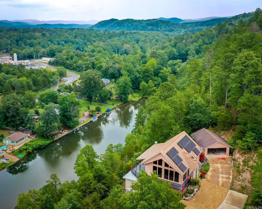 Enjoy stunning lake views from this custom-designed home perched above a serene tributary of Lake Hamilton. Whether you're relaxing in the spacious loft, entertaining on the expansive wraparound decks, or enjoying quiet mornings behind the soaring cathedral glass wall, the views are unforgettable—watch eagles glide across the water and take in the peaceful, natural beauty. This versatile home includes a private basement apartment, ideal for hosting guests or creating a separate income-producing space. With its inviting layout and tranquil setting, this property is perfect as a full-time residence, weekend retreat, or nightly rental. Live the lifestyle—sip coffee with sunrise reflections on the water, and unwind with sunset views that never get old. A rare blend of privacy, nature, and comfort awaits just minutes from town amenities.