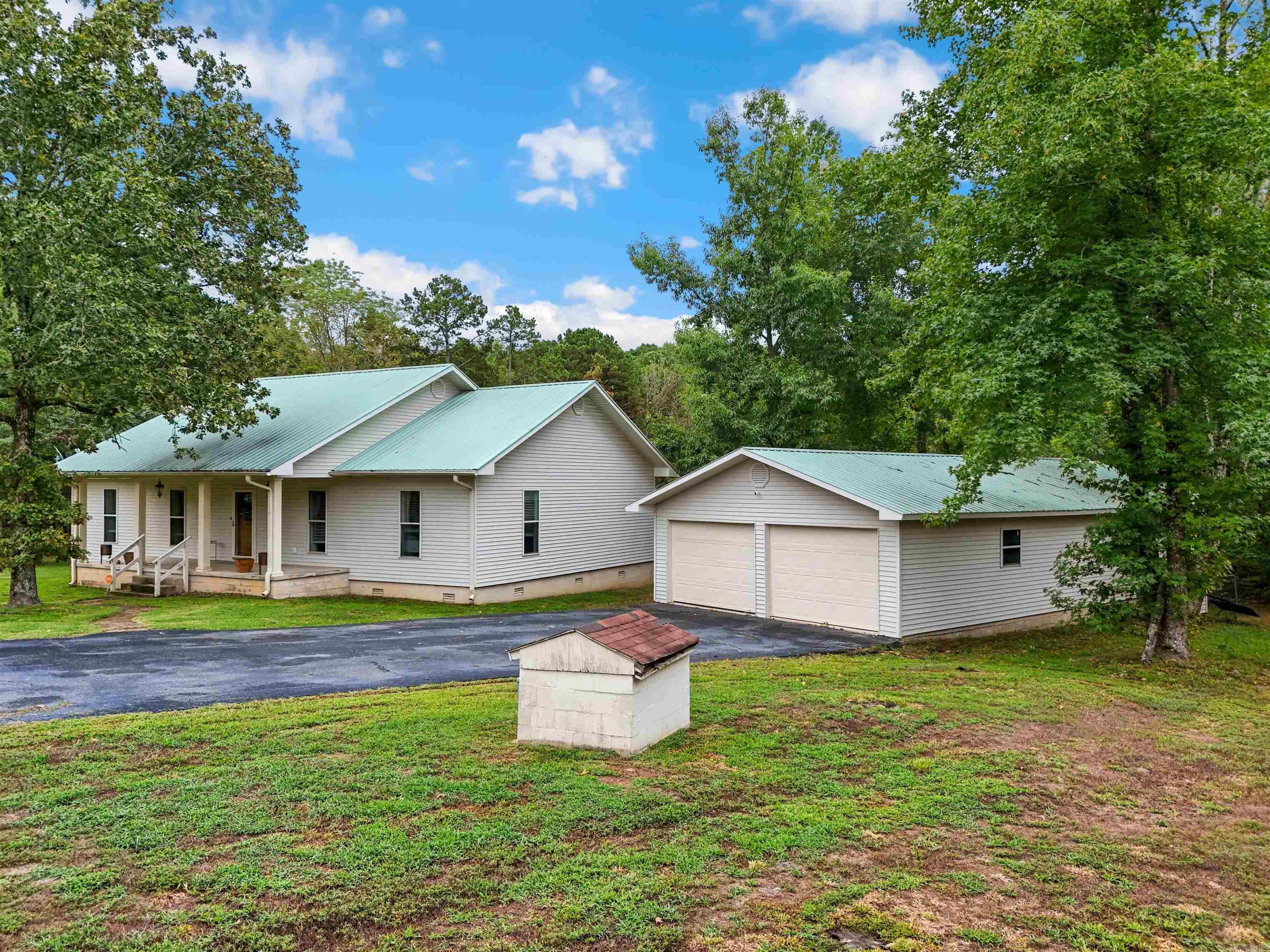 This 3 bed, 2 bath home in a country setting has 1736 sf, 9' ceilings, and sits on 7.12 acres. Enjoy peace and quiet, surrounded by nature and woods with vista views! Fall/Winter lake views. Wildlife abound! Deer blind stays. Wet weather creek, trails, grape vines, muscadine vines, fire-pit, 12' x 25' garden, 3 raised garden beds, built-in shop in the garage, 3 storage buildings, and a storm shelter! So close to the lake! Check out the aerial drone video and 3D tour. Call today to schedule your showing!