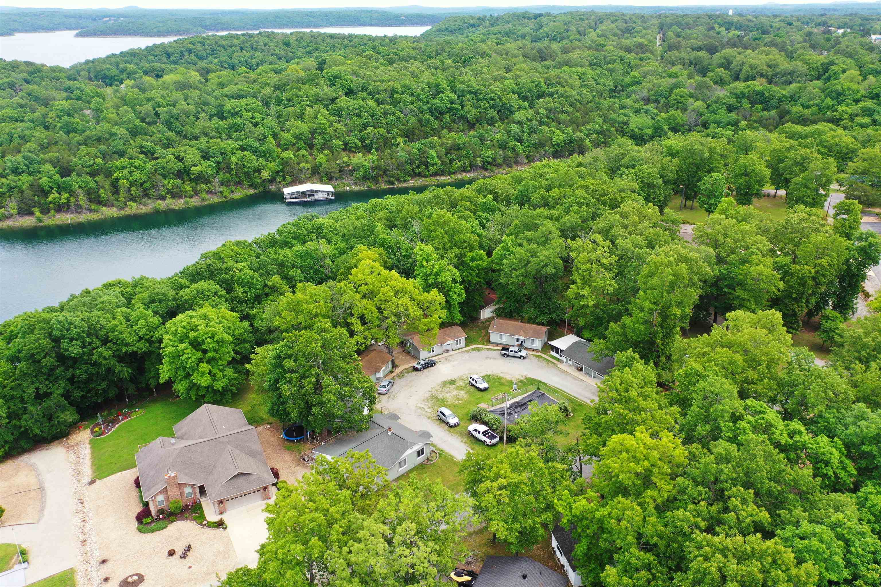 Many possibilities to Own, and or Operate this Bull Shoals Lake Retreat. That is bordering the Corp Land on Beautiful Bull Shoals Lake. This property features a Main House that is 3/beds to 2/baths, plus a detached garage, 4 rental units, and a storage building that has a coin operated Washer & Dryer for the guest to use. Relax on the large community deck, and enjoy the peaceful seasonal views of the lake, or take a walk down the meandering walking trail down to the lake. Maybe to do a little fishing from the shore. Located less than a mile from Bull Shoals Lake Access. This one is a real find, and an investment opportunity for any entrepreneur.