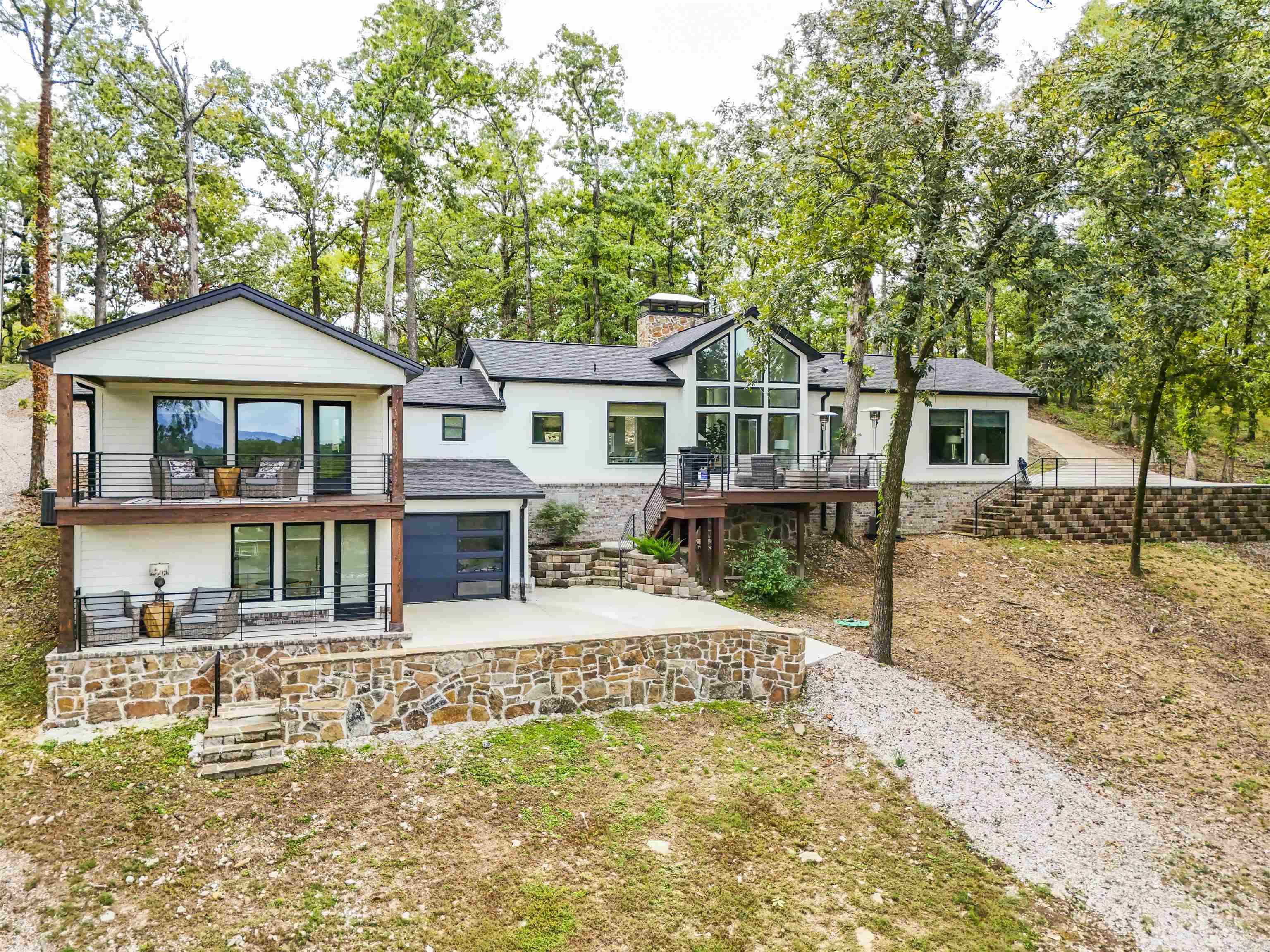 Nearly 1 acre on beautiful Lake Hamilton! The main level features 3 spacious bedrooms, 2 full bathrooms, a kitchen designed for entertaining, and showstopping fireplaces. Downstairs, you’ll find a loft-style apartment (separate entrance) with its own kitchenette and full bathroom—perfect for a private guest suite or in-law quarters. Enjoy spectacular lake views from nearly every room. Relax on the large deck overlooking the massive lot leading up to the water or step onto the second private deck off one of the bedrooms. The primary suite even has its own entrance with parking right outside and a prewired Tesla charger for convenience. Outside, you’ll love the single-stall fixed boat dock for easy lake access. This remodel was so extensive it feels like a brand-new build with 75% of the home being BRAND NEW. Every detail, fixture, and finish was thoughtfully chosen and installed with exceptional craftsmanship. Located outside the city limits, this property is also ideal for a short-term rental with no permit required.