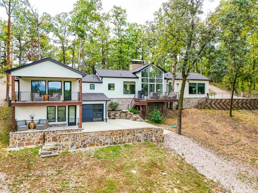 Nearly 1 acre on beautiful Lake Hamilton! The main level features 3 spacious bedrooms, 2 full bathrooms, a kitchen designed for entertaining, and showstopping fireplaces. Downstairs, you’ll find a loft-style apartment (separate entrance) with its own kitchenette and full bathroom—perfect for a private guest suite or in-law quarters. Enjoy spectacular lake views from nearly every room. Relax on the large deck overlooking the massive lot leading up to the water or step onto the second private deck off one of the bedrooms. The primary suite even has its own entrance with parking right outside and a prewired Tesla charger for convenience. Outside, you’ll love the single-stall fixed boat dock for easy lake access. This remodel was so extensive it feels like a brand-new build with 75% of the home being BRAND NEW. Every detail, fixture, and finish was thoughtfully chosen and installed with exceptional craftsmanship. Located outside the city limits, this property is also ideal for a short-term rental with no permit required.