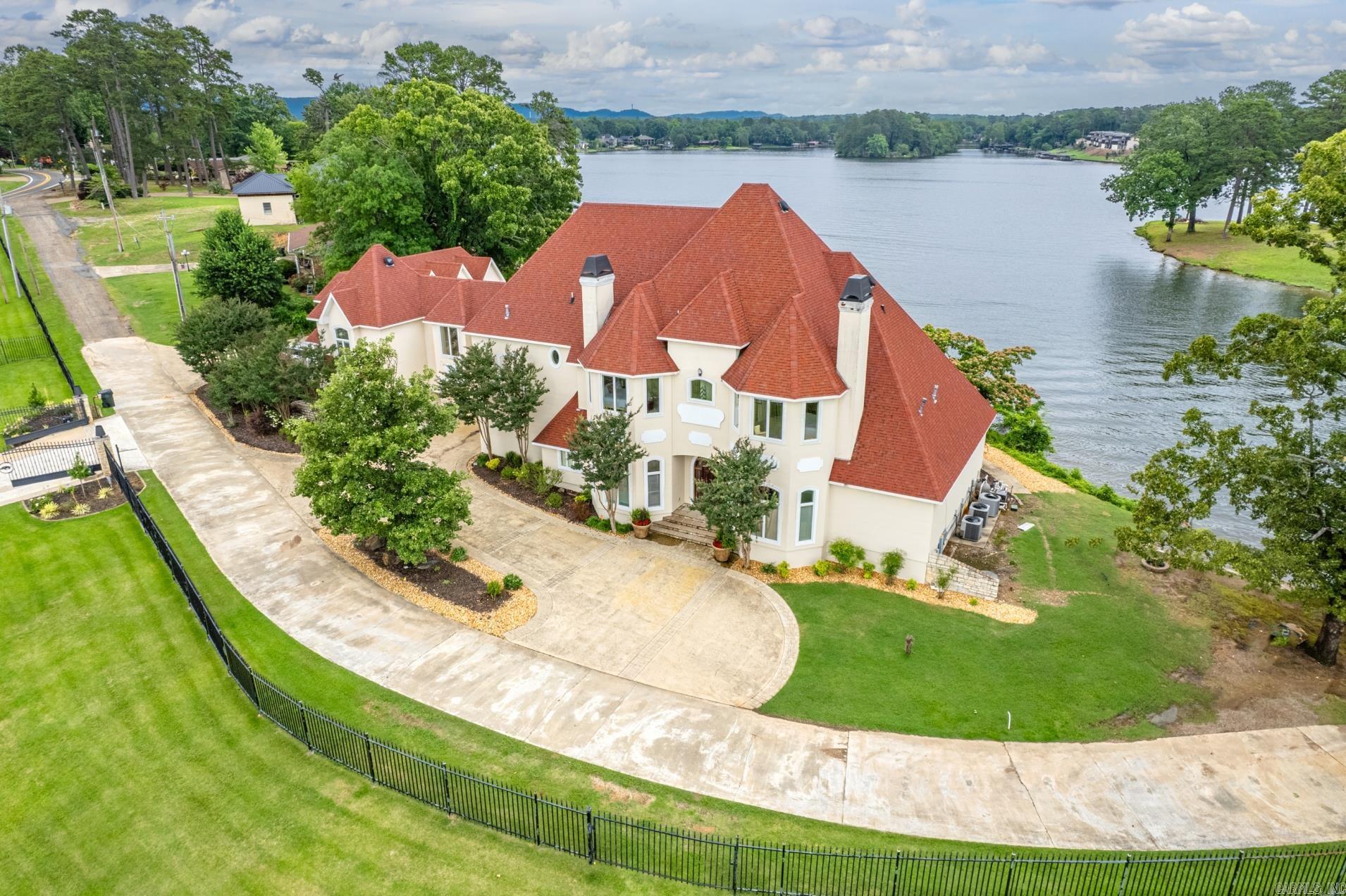 Luxury lake living never looked so good! This gorgeous 7 bedroom, 7.5 bath home features a chef's kitchen, guest quarters, elevator, media room and a master en'suite you'll never want to leave. This home sits on 241' of prime waterfront property on the shores of beautiful Lake Hamilton with a 2 stall covered boat dock. For those lazy days of summer when you aren't boating you can relax by your infinity pool. The family chef will love preparing meals in the gourmet kitchen with both gas and electric stoves and indoor grill. When the sunsets on your day you can cozy up in the media room for movie night or lounge your winter nights by one of the 3 fireplaces. Everything you've ever dreamed of and so much more. This property is currently being utilized as a short term rental vacation home with an outstanding return on investment. Showings are by appointment only between vacation bookings. Schedules yours today and start packing tomorrow!