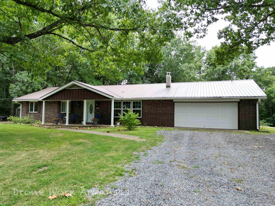On a well-maintained county road in the beautiful Ozark Mountains, just a short drive from the Buffalo National River in a very peaceful rural area, you'll find this immaculate move in ready 3 BR/2BA brick home with metal roof on 2.48 ac m/l. Main level of home is 1952 SF heated/cooled & 2 car garage.  Large front porch and amazing sunsets from the large screened in sunporch on the back, complete with mountain views. Waterproof LVP flooring recently installed in bedrooms, hallway and living room. Walk in shower in primary. Sculptured Oak kitchen cabinets give the spacious kitchen a unique touch. Level yard w/mature fruit trees. Backyard is chain link fenced, while most of property is contained by welded wire fencing.  Nice flat front and side yards, hill at back edge of property away from house, behind the chain link fence. Central H/A. Woodstove in large formal living room. Professionally installed & maintained whole house generator uses propane fuel automatically comes on if power outage occurs.  Large 500 gallon propane tank is owned.  Large storage building with electric. Rural water & private septic. PJ Fiber high speed internet.  Adjoining 20 acres for sale, MLS#: 24017290