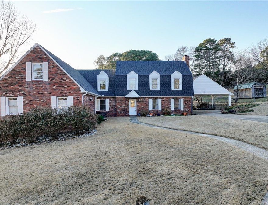 Custom-built, one-owner 5-bedroom, 5-bath home on a corner lot of nearly 1.3 acres. Grand entry with high ceilings and staircase. Den features built-in shelving and gas fireplace. Spacious primary suite with walk-in closet and en-suite bath. All bedrooms and full laundry room located upstairs, plus additional washer/dryer hookup downstairs.  Kitchen-adjacent workshop with built-in shelving. On-demand water heater. Expansive backyard with two peach trees, apple tree, and blackberry bush.  Detached approximately 1,600 sq ft studio includes a three-quarter bath, loft, and multiple rooms—ideal for studio, workspace, or flexible use (buyer to verify permitted uses). RV-height carport.  Versatile property with space to live, work, and create. Great central location to Oaklawn and the National Park