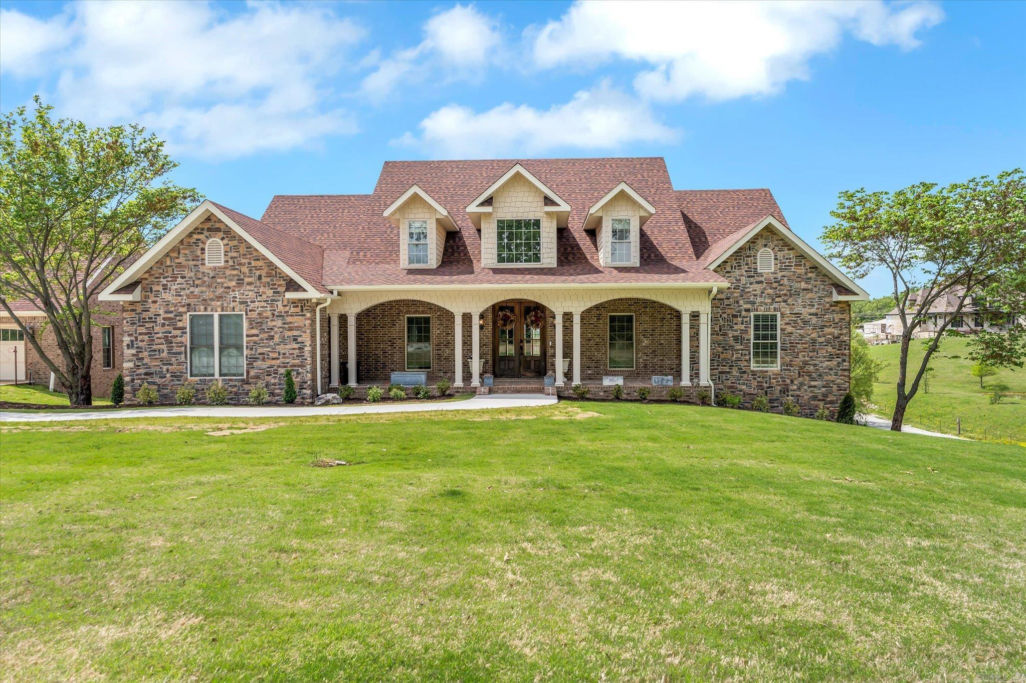 Just outside the Jonesboro city limits, a private five-acre retreat offers the perfect balance of space, design, and natural beauty. Surrounded by open land and mature trees, this custom-built home blends elegance with everyday functionality across a well-designed, expansive layout. Inside, you'll find four bedrooms, five full bathrooms, and two half baths, along with versatile living spaces designed for today's lifestyle including a formal dining room, dedicated office, sunroom, home theater, and a newly finished bonus area with its own entrance off the three-car garage. Hardwood flooring, vaulted ceilings, custom built-ins, and a gas fireplace add timeless character throughout the main living areas. The kitchen was built for both hosting and home cooking, featuring an oversized island, gas range, stainless appliances, granite countertops, and direct access to the sunroom and outdoor deck. From here, enjoy sweeping views of the private pond, rolling acreage, and peaceful surroundings. The main-level primary suite offers a quiet escape, complete with a spacious ensuite bath featuring a soaking tub, walk-in shower, dual vanities, and generous storage.