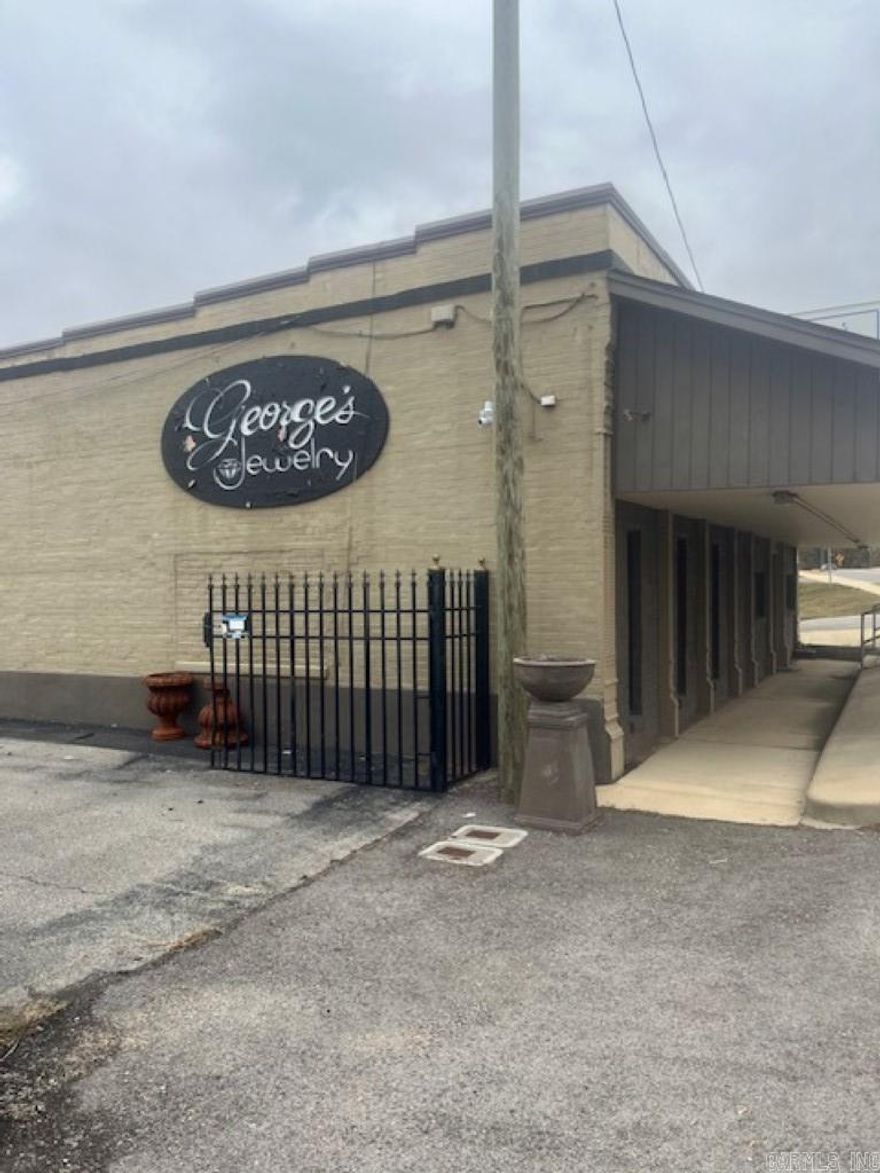 Formally was George's Jewelry Store. 3 separate buildings, office and jewelry store. 1 concrete building and 1 wood frame building. Paved parking lot, partly fenced on east side of the property.
