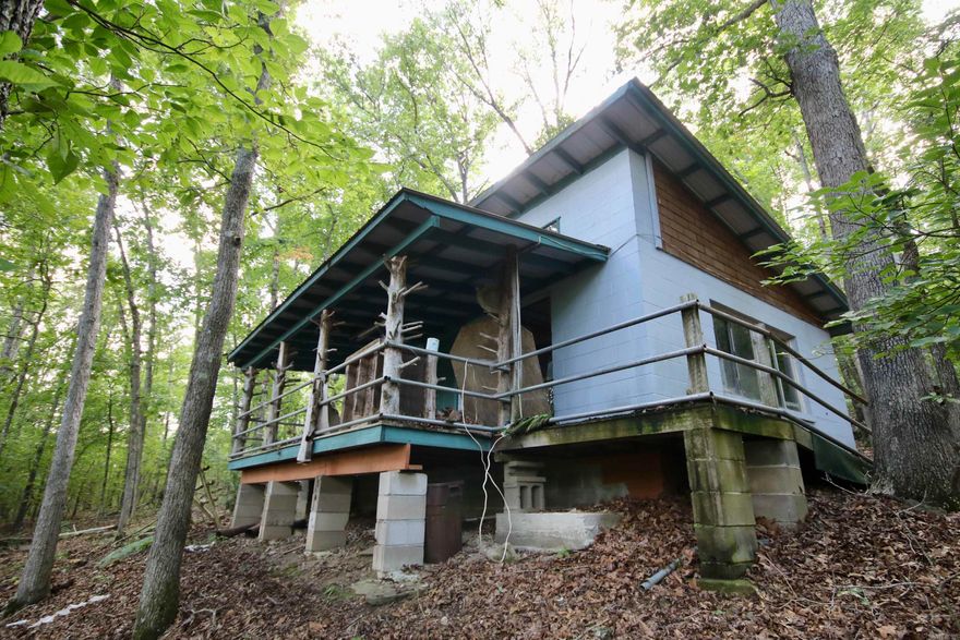 Escape to your own private haven in the heart of the Ozarks with this extraordinary off-the-grid hunting cabin. Nestled in seclusion, this spacious, well-built cabin offers the utmost privacy, making it the perfect retreat for outdoor enthusiasts and nature lovers. The cabin features two cozy lofts and a convenient kitchen area, providing a comfortable and rustic living space. Wired for a generator, you can enjoy modern amenities while being completely self-sufficient. Surrounded by dense hardwood timber, including magnificent red and white oaks, this property is a haven for abundant wildlife. Deer, bear, and turkey are just a few of the species that call this area home, leaving a plethora of game sign throughout the terrain. For hunting and recreational enthusiasts, this property is a dream come true, offering numerous opportunities to pursue your passion. Explore the majestic rock formations, meander alongside the peaceful wet weather creek, and discover the breathtaking waterfall that graces the land. This off-the-grid cabin not only fulfills your wildest outdoor dreams but also presents a fantastic investment opportunity. Don't miss the chance to own a piece of the Ozarks.