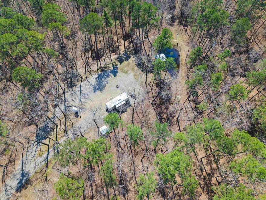 Discover the potential of this 2.31± acre property conveniently located in Mount Ida with Highway 188 E frontage. Featuring a circle drive for easy access, this property is already equipped with a 100-amp electric service, septic system, and two wells. Two water spigots are in place, making it ideal for RV setups or future development.  Enjoy the nice setting with a small pond complete with an 8x12 covered deck—perfect for relaxing and taking in the natural surroundings. The property borders National Forest on the east side, offering added privacy and direct access to outdoor recreation. Located just approximately 5 miles from the Little Fir Boat Ramp, this tract is well-suited for a weekend getaway, full-time living, or investment opportunity near Lake Ouachita.