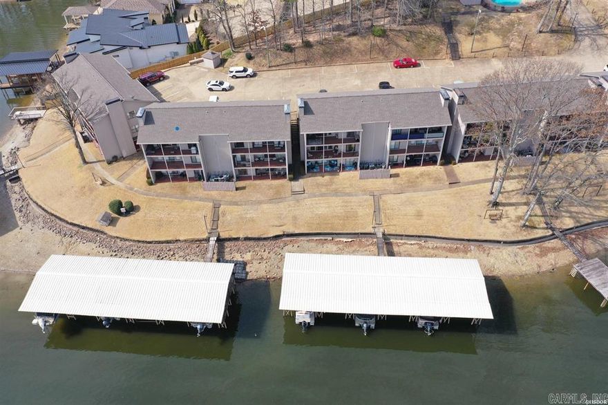 Fabulous waterfront 2-bedroom 2 bath condo with covered boat slip and lift!  Upper unit facing northeast for the breathtaking views and afternoon shade!  Main Channel location, fireplace, covered patio with sunrise to sunset views!  Gated complex offers inground swimming pool, fishing dock and grilling areas.  Assigned parking with room for quests.  Note the extra window at dining table offering special lake views as well!  STR's are permitted at this time.