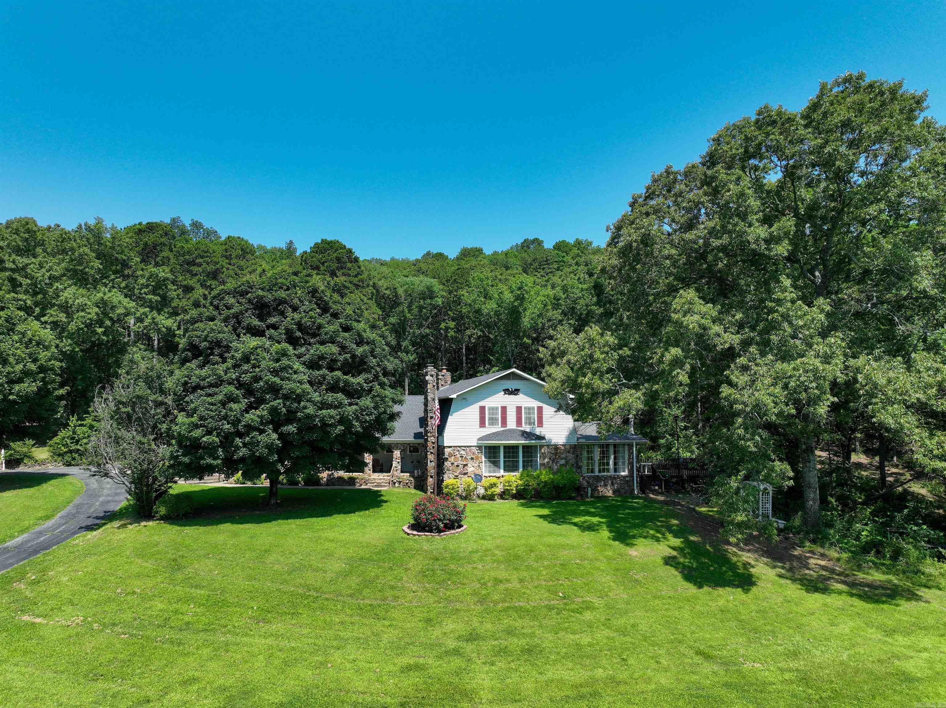 Nestled on a beautiful 13.5 acres, this home offers comfort & privacy for the entire family. With a thoughtfully designed floor plan, the main level features a cozy living room with fireplace, a dining room, & a large kitchen perfect for entertaining. The keeping room with its own fireplace offers warmth & charm, while the sunroom offers a bright space to enjoy the natural beauty surrounding the property. Additionally, the main floor includes a convenient ½ bath & laundry area. Upstairs, you'll find the primary suite, along with three additional bedrooms & a guest bathroom providing plenty of room for family or guests. Home offers a partial basement for storm shelter or storage. Step outside to drop your line in the fully stocked pond with a private pier. The property also includes a barn, ideal for storage or hobbies, a chicken coop for your own homesteading needs & circular driveway. Located just 5-10 minutes from several access points on the Little Red River & only 25 minutes from the stunning Greers Ferry Lake, this property is a nature loverās dream. With easy access to outdoor activities like fishing, boating, & hiking, youāll have endless ways to enjoy the area.