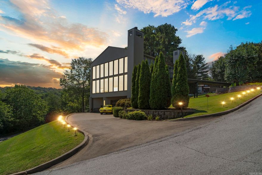 Presenting the final architectural triumph of internationally acclaimed solar architect James Lambeth. Set on a serene half-acre lot with views of Lake Lucille in downtown Fayetteville, this custom home is a true original. It offers four spacious, elegantly finished bedrooms and two and a half luxurious baths. A large family room complements a versatile game/media roomāclimate-controlled for use as a garageāwith a built-in entertainment center. Unique amenities include a private three-story elevator, underground electric pet fence, soft water filtration, laundry chute, and a stunning second-story deck with street-level access. The chef-inspired kitchen, highlighted by a sleek bar, is ideal for entertaining. The living room features a dramatic two-story travertine fireplace and a 17-foot wall of windows with lake views. A spiral staircase, built-in media center, and wood-burning fireplace complete the space. The primary suite offers a marble-clad bath with freestanding tub, fireplace, and double shower. This home is living work of art. Schedule your showing today!