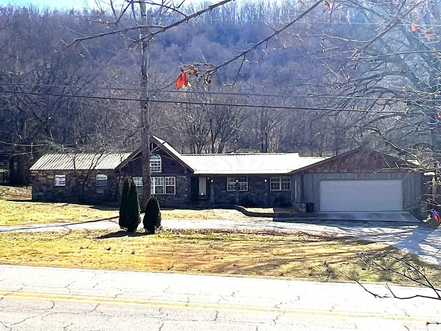 Spacious living meets Ozark scenery just outside Mountain View in desirable Stone County!  This 4 bedroom, 3 bath stone home sits on approximately 1 acre with beautiful mountain views and room to breathe. The inviting exterior and metal roof set the tone for a comfortable, well-built home designed for everyday living and gatherings alike. Inside you’ll find generous living areas and a flexible layout suited for family, guests, or multi-generational living. The cozy kitchen easily flows to the dining and main living space featuring a grand floor-to-ceiling stone fireplace and cathedral ceiling as the centerpiece of the home. The private primary suite offers a true retreat with a custom shower and an in-room jacuzzi tub for relaxing at the end of the day. A 30x30 metal building with electric adds excellent versatility — ideal for a workshop, equipment storage, or hobby space. Central heat and air, attached garage, and easy highway access make daily life convenient while still enjoying the peaceful feel of the countryside. Located just minutes from Mountain View’s shops, music, and river recreation, this property offers the balance of privacy and accessibility buyers are looking for.