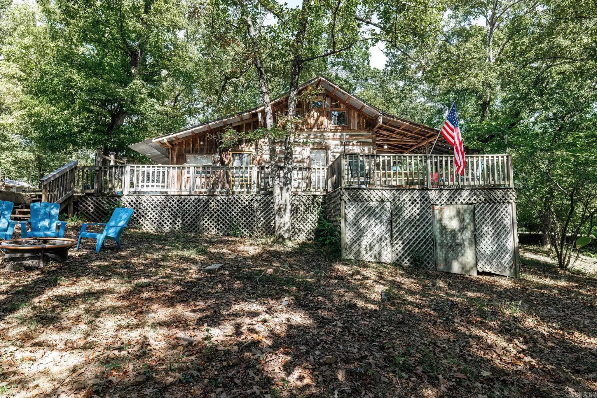 Nestled in the serene embrace of the picturesque Lake Greeson, this enchanting three-bedroom, two-bathroom cabin offers a timeless escape from the hustle and bustle of modern life. Built in the 1800s, this historic gem exudes rustic charm while providing all the modern comforts you desire. Only 30 minutes away from Crater of Diamonds and Daisy State Park. Stepping through the threshold, you'll be greeted by a warm and inviting interior, with each room thoughtfully furnished to maintain the cabin's original character. The spacious living area boasts a cozy fireplace, perfect for chilly evenings, while the fully-equipped kitchen ensures your culinary needs are met. The three bedrooms are spacious and inviting, promising a restful night's sleep for you and your guests. Two pristine bathrooms offer convenience and comfort, ensuring everyone's needs are met. Perhaps the highlight of this enchanting retreat is the private hot tub, where you can soak under a canopy of stars, surrounded by the tranquility of the natural world. This cabin is a turnkey opportunity, fully furnished and ready to continue its successful journey as an Airbnb, making it an exceptional investment property.