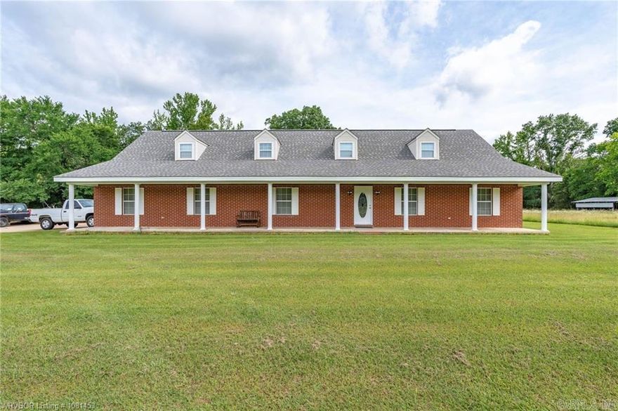 Nestled in the scenic Ouachita Mountains, this beautiful property features state highway frontage and sits directly across from the Arkansas Muddy Creek Wildlife Management Area, making it an outdoor enthusiast’s dream. The stately brick home sits on approximately 5 acres, while the remaining acreage remains pristine and untouched. Built in 1990, the home offers over 3,000 square feet with 4 spacious bedrooms, 3 full bathrooms, walk-in closets, formal entryway, formal dining, eat-in kitchen, and generous living spaces. Constructed with durable 2x6 framing for energy efficiency, the home also features four dormer windows that fill the upper level with natural light. Full-length covered porches in the front and back provide the perfect place to relax and enjoy views of the creek and surrounding mountains. The kitchen includes a bay window overlooking the creek, and a bonus space off the laundry room offers potential for a walk-in pantry. A high-efficiency wood stove adds warmth and charm. The property also includes a red barn with equipment doors, woodshed, and tool shed. Wildlife is abundant, and creek fishing is excellent. New flooring upstairs, downstairs, and in the kitchen adds