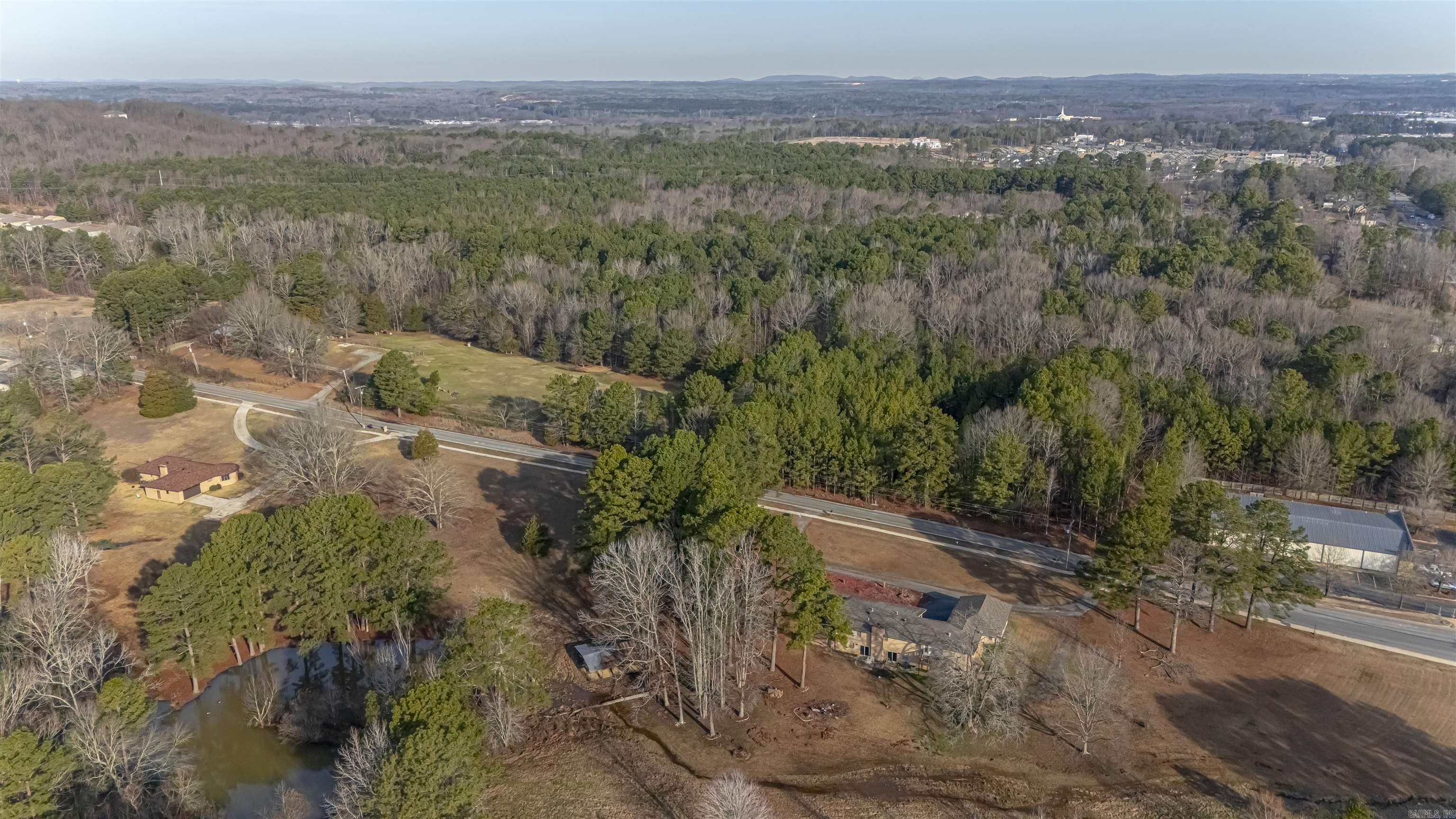 Well built, spacious home on 7 acres walking distance to Robert L Davis Elementary. 4 bedrooms, 2 living areas. Zoned C1 but house is currently grandfathered in and being used as a residential rental. Future development must be commercial.
