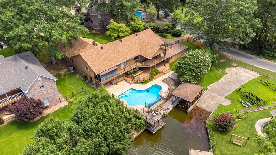 Welcome to Your Waterfront Retreat in the Lake Hamilton School District! Located in a charming, well-established neighborhood on the outskirts of town, this beautifully updated 4-bedroom, 3.5-bath traditional home offers 3100 square feet of comfortable living with stunning lake views. Step into the heart of the home—a fully remodeled kitchen featuring sleek quartzite countertops, custom cabinetry, a spacious island, and top-of-the-line stainless steel appliances. Perfect for cooking and entertaining alike. Enjoy outdoor living at its finest with multiple composite decks and an infinity pool that overlooks a quiet cove on Lake Hamilton—ideal for peaceful mornings or evening gatherings. The walk-out basement is an entertainer’s dream, complete with a large built-in bar and direct access to the outdoor spaces. Don't miss your chance to own this incredible home in the sought-after Lake Hamilton School District. A true gem with space, style, and lakefront serenity!