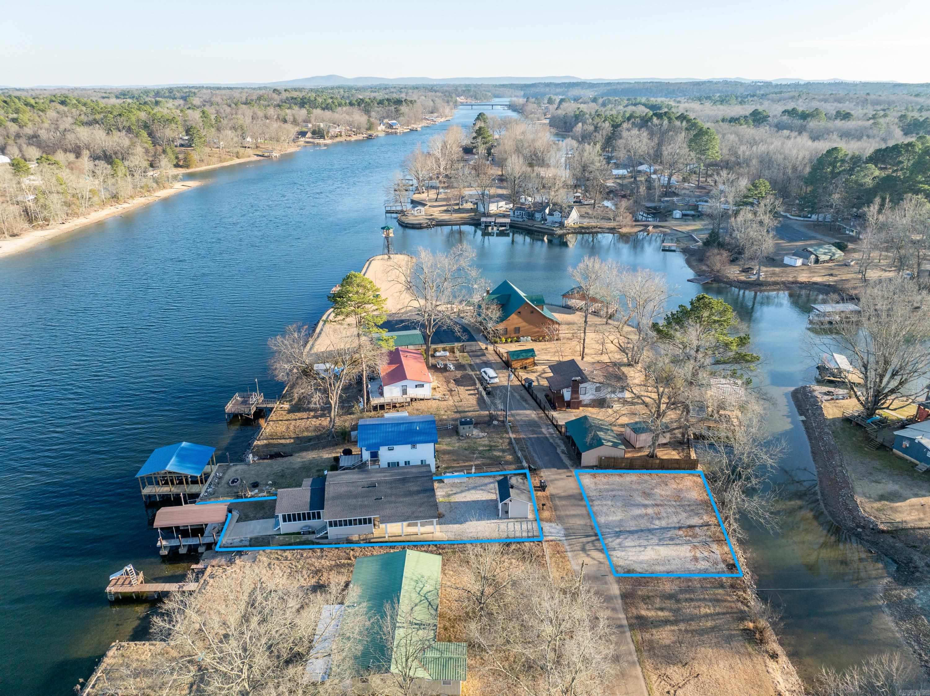 This turn-key Lake Hamilton cottage is located on the main channel and includes an additional lake-front lot, offering abundant potential. The property includes a covered boat dock w/jet ski lift, a fully-fenced & gated yard, and a separate storage shed with electricity - which could easily be converted into a guest suite or she-shed. Inside, the 3-Bedroom, 2-bath home features an open/airy floor plan with a screened front porch/mud room, and a sunroom with an eat-in bar to enjoy dinner and lake views year-round. You'll appreciate the newly-installed UV-blocking blinds, keeping the sunroom cool & comfortable, even on the brightest Summer days. Sellers spared no expense on all new furnishings, decor, and a fully-equipped kitchen. Home was renovated top-to-bottom late 2023, including a new roof. Don't miss the opportunity to have a darling Lake Hamilton home at an affordable price. Agents see remarks.