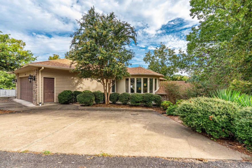 Welcome to your dream home on beautiful Lake Hamilton! This stunning multi-level contemporary residence combines timeless style with the ultimate in waterfront living. Nestled among mature trees and landscaped grounds, the property features expansive wraparound decks and soaring windows that capture breathtaking lake views from nearly every angle.  The grand double-door entry opens to bright, open living spaces highlighted by a dramatic bay window and natural light throughout. Multiple levels provide both spacious gathering areas and private retreats, while a walkout basement and private courtyard with a charming water feature add to the home’s appeal.  Perfect for entertaining or relaxing, this property offers seamless indoor-outdoor living with decks overlooking the water and lush surroundings. Best of all, you’ll enjoy direct access to Lake Hamilton with your own two-stall covered boat dock, ideal for boating, fishing, or sunset cruises.  A rare opportunity to own a home that blends architectural character, comfort, and the very best of lakeside living.
