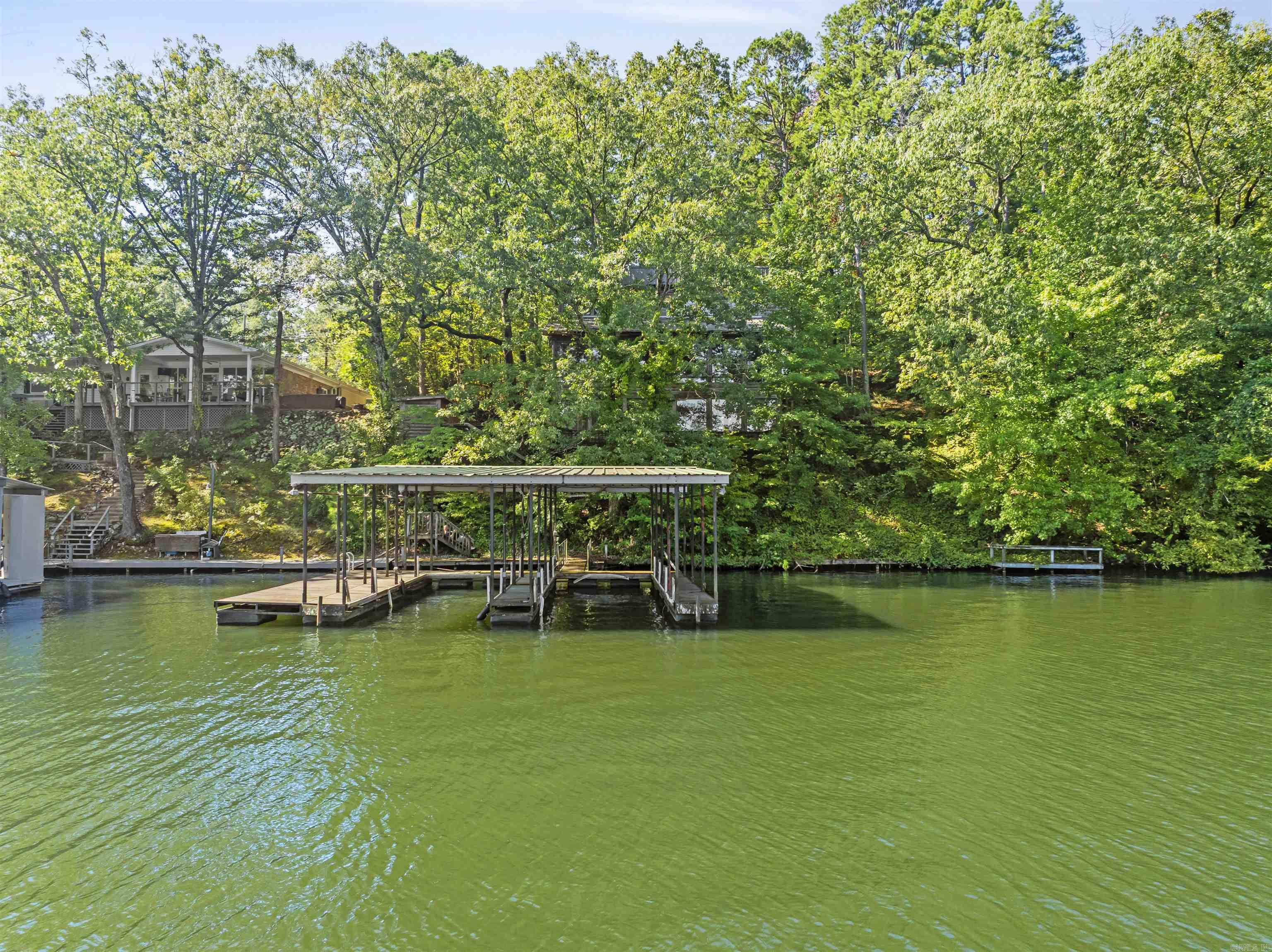 A rare opportunity to create your ideal lakefront retreat on Lake Hamilton! This property offers three combined waterfront lots with wide-open views and the convenience of a two-stall covered boat dock plus a swim dock, already in place for enjoying the water. With room to spread out and design exactly what you want, the true value here is in the land, shoreline, and the future potential it offers. The property is located near Carpenter Dam and Garvan Woodland Gardens, placing you close to some of the lakeās most scenic and sought-after areas. It is in the county and within the Lakeside School District (buyer to verify attendance zone). Please note: Existing improvements convey as-is. No value is given to the structure, and access to the house will not be permitted due to safety concerns. Showings are of the land and grounds only. This is a chance to build your dream lakefront home on one of the most beautiful stretches of Lake Hamilton. With multiple lots, established docks, and stunning views, the possibilities are wide open.