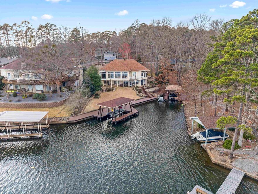 Stunning WATERFRONT on 380 acre Lake Coronado! 3 Bed/2.5 Bath with over 4000 sq ft + Huge 16'x21' Shop Area! 120' Seawall and Covered Dock with Lift! Trex decking boardwalk and beautiful Landscaping! 5 Zone Irrigation from the lake + Waterfall landscape feature! The Granite Island Kitchen offers a Downdraft Range, Loads of Cabinets (with slide-outs), Indirect Lighting, and Eating Bar! The Large Open-concept Dining Room, and Living Room w/Wood Burning Fireplace boast a High Tray Ceiling and open to the Wall of Windows in the Huge Sunroom overlooking the Lake! The Primary Suite w/Walk-in Closet has been completely updated, with Tile Shower, Ceramic Tile Floors, and Jetted Tub! Downstairs you will find a Spacious Rec Room with Wet Bar and Double Door to Beautiful Patio & Lawn, additional Storage, 2 Bedrooms, a Guest Bath, and the Shop Area w/Workbench! Central Vacuum in this Meticulously maintained home! Hot Springs Village offers 11 Lakes & 9 Golf Courses, 20+ Miles of Walking Trails, Tennis, Pickleball, Mini Golf, Bocce Ball, Dog Park, Fitness Center, Indoor & Outdoor Pools, Restaurants, Churches, and much more! SEE VIDEO TOUR