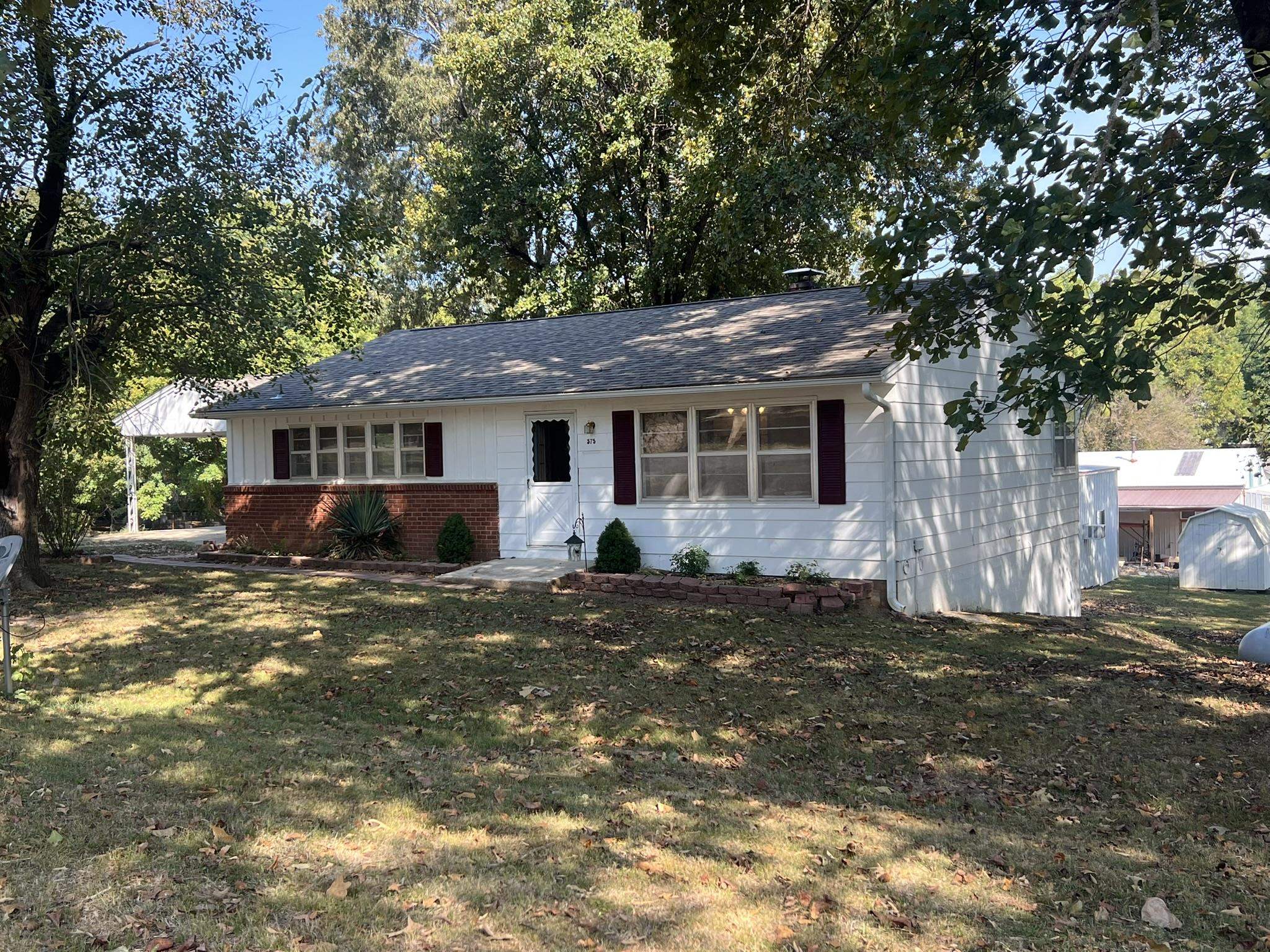 3BR/2BA Home over Walk-out Basement plus Shop with high speed fiber internet. This home had a new roof in 2023 has an open floor plan with nicely finished hardwood flooring on most of the main floor. The kitchen has vinyl flooring with custom oak cabinetry and modern counter tops and includes an electric range, built-in Microwave and dishwasher. Dining room separates the kitchen from the living room. Both upstairs bedrooms are large and have hardwood flooring, the Master suite has a walk-in shower and houses the laundry area. The main bath has a full tub/shower unit. The basement has 2 finished rooms, bedroom 3 is 10x13 and there is an exercise room 14x21. There is also a utility sink, second set of washer/dryer hook-ups and a shower in the basement which has 2 large unfinished storage areas and an exit door to the back yard. Outside there is a 1 car attached carport with nice covered sitting area and deck which overlooks the 30x35 Shop. Shop has concrete floor and electric and is insulated, propane central heat unit plus window AC. There are 2 garage doors and a personal entry door. 8x10 storage building/mower shed. Many mature trees make for a shady yard. Close to schools.