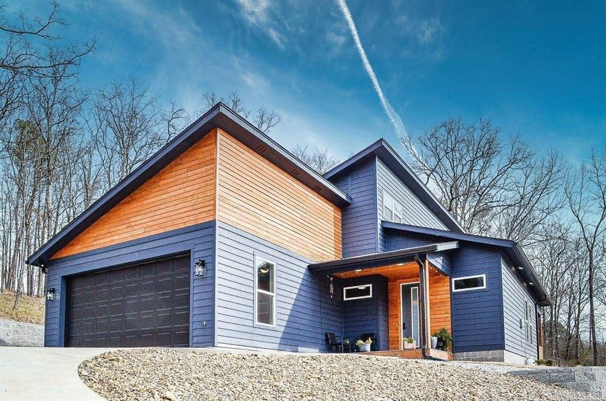 Modern Elegance Meets Natural Serenity in this stunning contemporary 3-bedroom, 2.5-bath home nestled on over half an acre with breathtaking views of the golf course. Designed for both comfort and style, this open-concept residence features vaulted ceilings, sleek modern lighting, and wide plank luxury vinyl flooring throughout.  The gourmet kitchen is a showstopper, boasting quartz countertops and backsplash, under-cabinet lighting, stainless steel appliances, and a large island complete with wine storage—perfect for entertaining. The main-level primary suite offers a tranquil retreat with a custom walk-in shower and a generous walk-in closet.  Upstairs, you'll find a versatile bonus room, two additional bedrooms, and a full bath—ideal for guests or a growing family. Step outside to your private covered patio, a peaceful haven to enjoy nature and watch local wildlife.  Located in the desirable Diamondhead community, residents enjoy access to a sparkling lake, swimming pool, championship golf course, and tennis courts. This home is the perfect blend of luxury, functionality, and natural beauty.